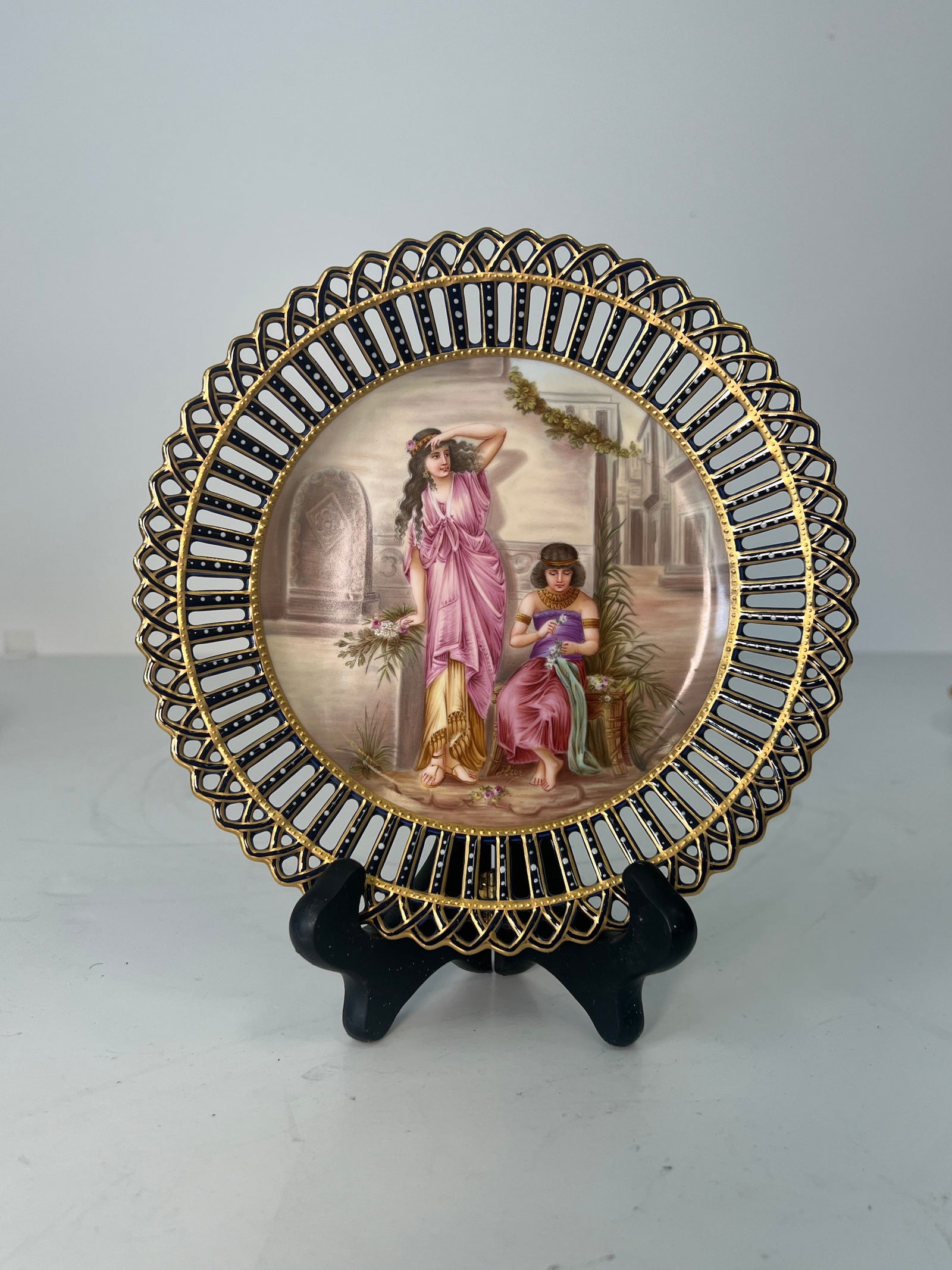 A ROYAL VIENNA RETICULATED PORCELAIN PAINTED PLATE, CIRCA 1920: A ROYAL VIENNA RETICULATED PORCELAIN PAINTED PLATE, CIRCA 1920 , DEPICTING A WOMAN AND A BOY DRESSED ON EGYPTIAN ATTIRE, MARKED WITH ROYAL VIENNA BEEHIVE MARK AND TITLED, DIMENSIONS DIAMETER: 8"