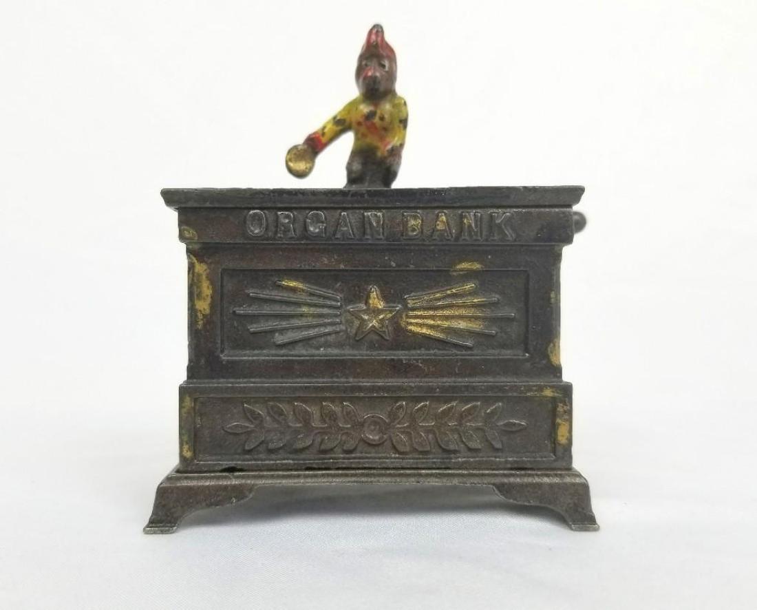 The Organ Bank (Miniature) Mechanical Bank: The Organ Bank (Miniature) is one of a series of four monkey and organ mechanical banks, designed and manufactured by Louis Kyser and Alfred C. Rex, of Frankford, Pennsylvania. It has the distinctio