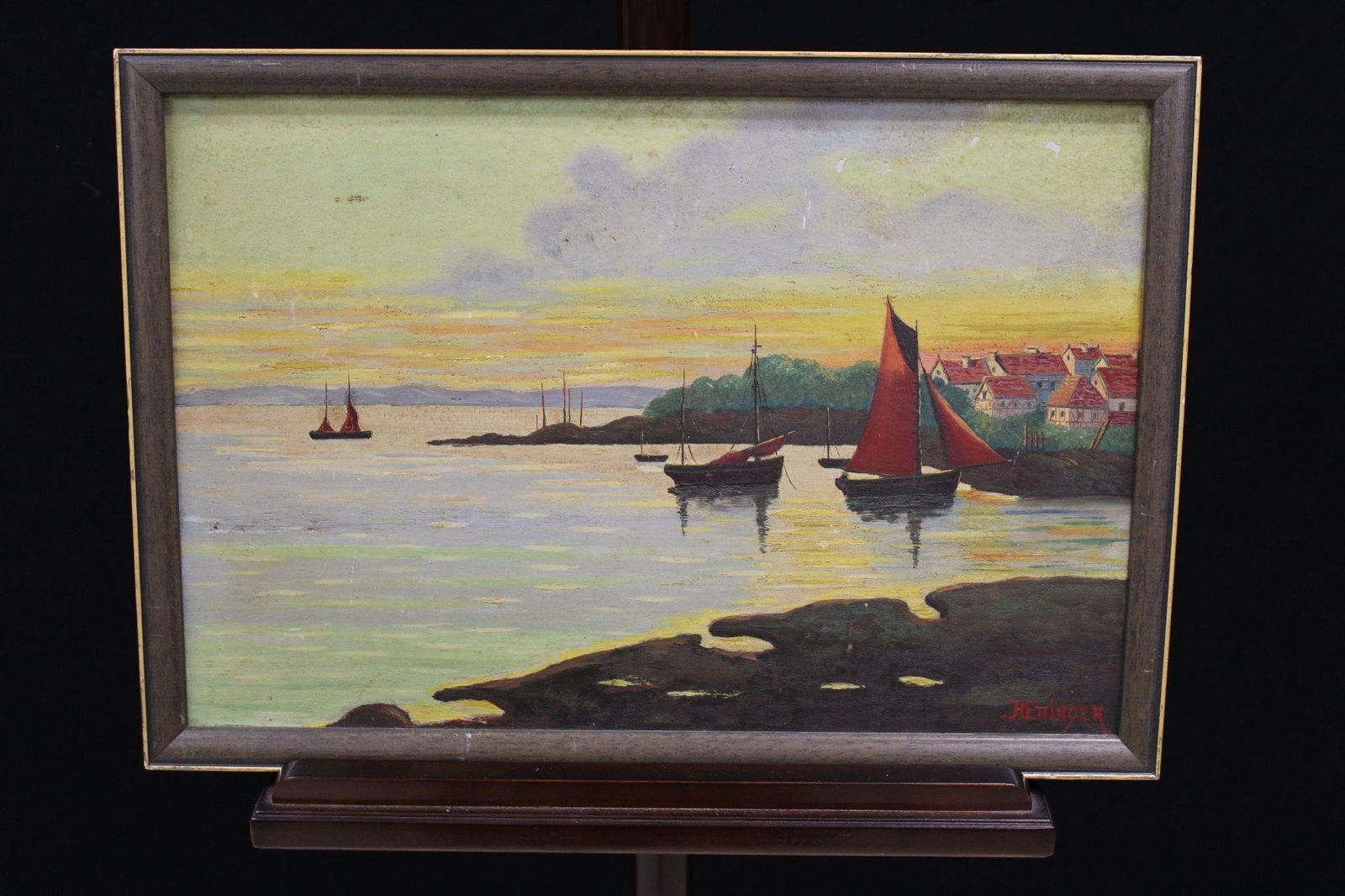 Maritime Sunset/Coastal Scene Oil Painting Signed: This is an oil painting depicting a serene maritime scene during sunset. It features sailboats with red sails anchored near a coastline, with a vibrant sky reflecting on the water. The style and compo