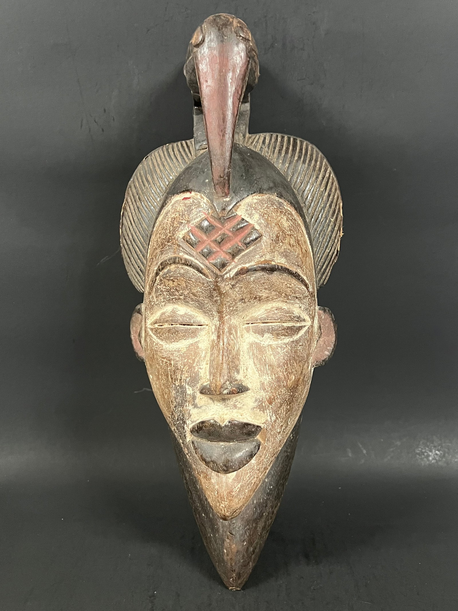 Carved Wood Punu Mask: African Tribal Art Carved Wood Punu Mask. The dimension is 17 inches high x 7 inches wide. Please be aware that some of the items are vintage, secondhand, old ages, antiques and may have a defects or