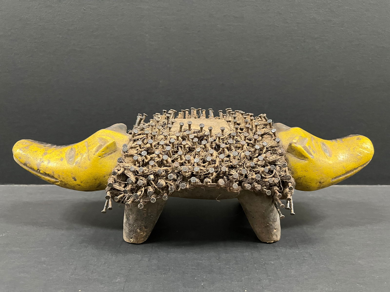 Bacongo Double Head Dog Nail Fetish Statue: African Tribal Art Carved Wood Bacongo Double Head Nail Fetsih Statue. The dimension is 5 inches high x 15 inches wide. Please be aware that some of the items are vintage, secondhand, old ages, antiqu