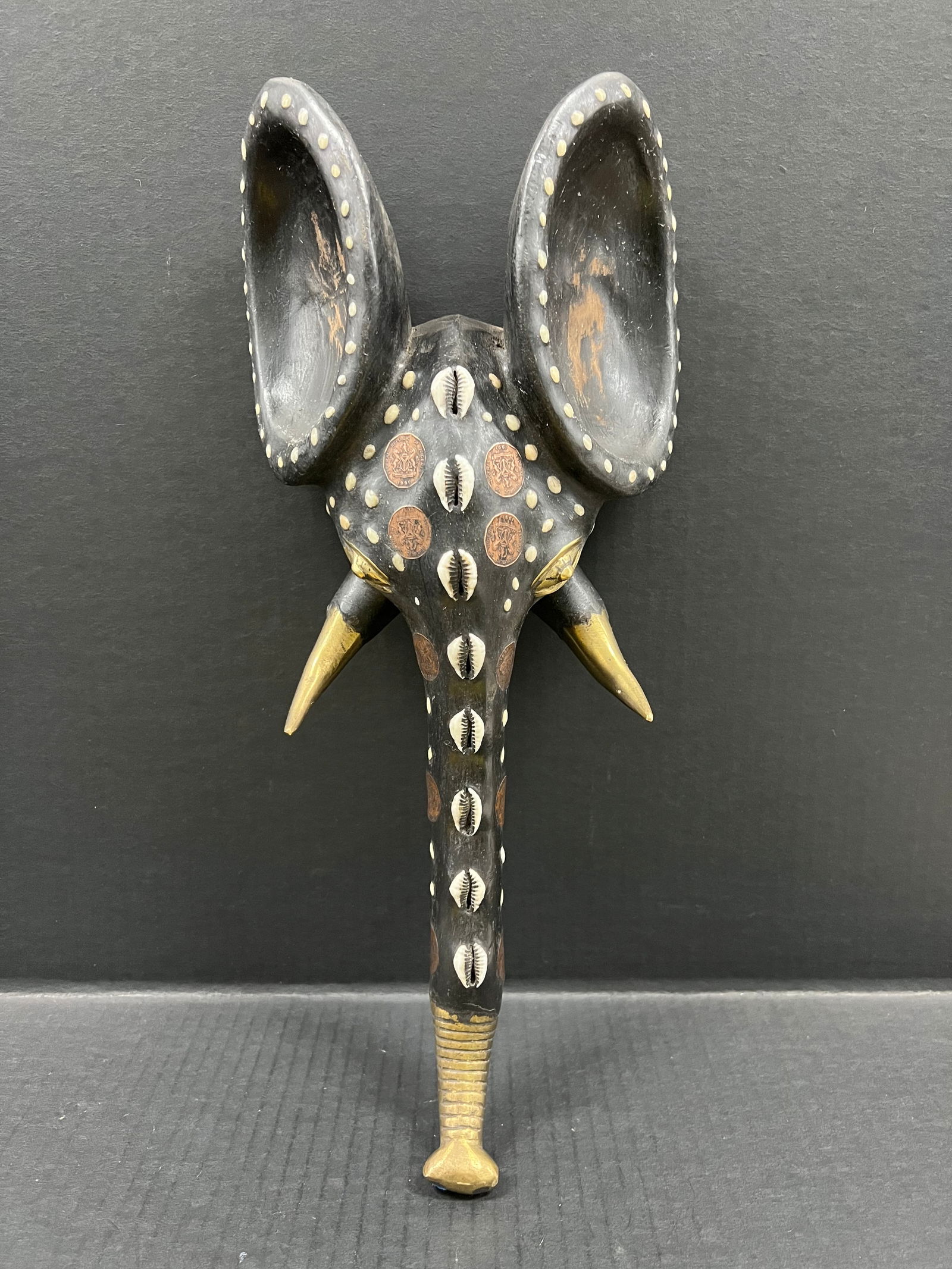 Babanki Elephant Mask with Embedded Coins: African Tribal Art Carved Wood Babanki Elephant Mask with embedded Coins. The dimension is 16.5 inches high x 7.5 inches wide. Please be aware that some of the items are vintage, secondhand, old