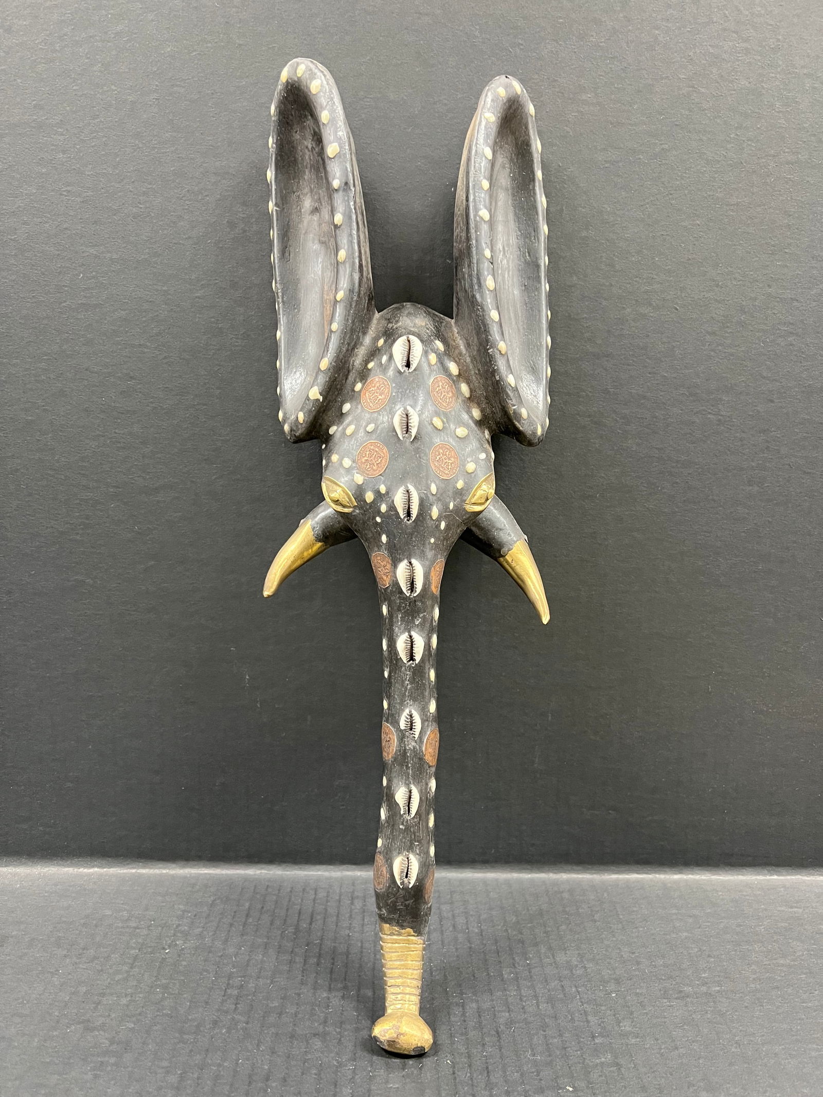 Babanki Elephant Mask with Embedded Coins: African Tribal Art Carved Wood Babanki Elephant Mask with embedded Coins. The dimension is 20.5 inches high x 6.5 inches wide. Please be aware that some of the items are vintage, secondhand, old