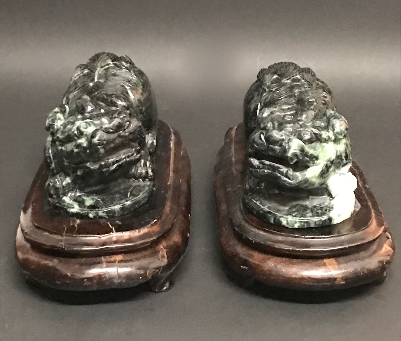 Pair of Burmese Dark Green Jade Foo Dog with Wooden Stand: Pair of Burmese Dark Green Jade Foo Dog with Wooden Stand. The dimension is 3 inches high x 6 inches wide. Please be aware that some of the items are vintage, secondhand, old ages, antiques and may