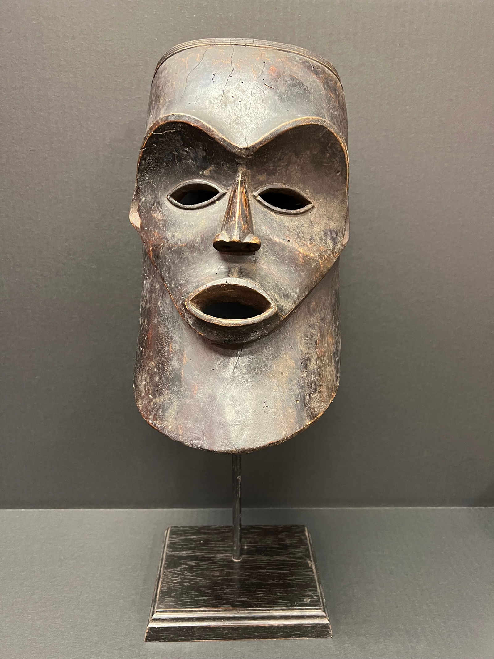 Carved Wood Makonde Mask with Metal Stand: African Tribal Art Carved Wood Makonde Mask with metal stand. The dimension is 21 inches high x 8 inches wide. Please be aware that some of the items are vintage, secondhand, old ages, antiques and ma