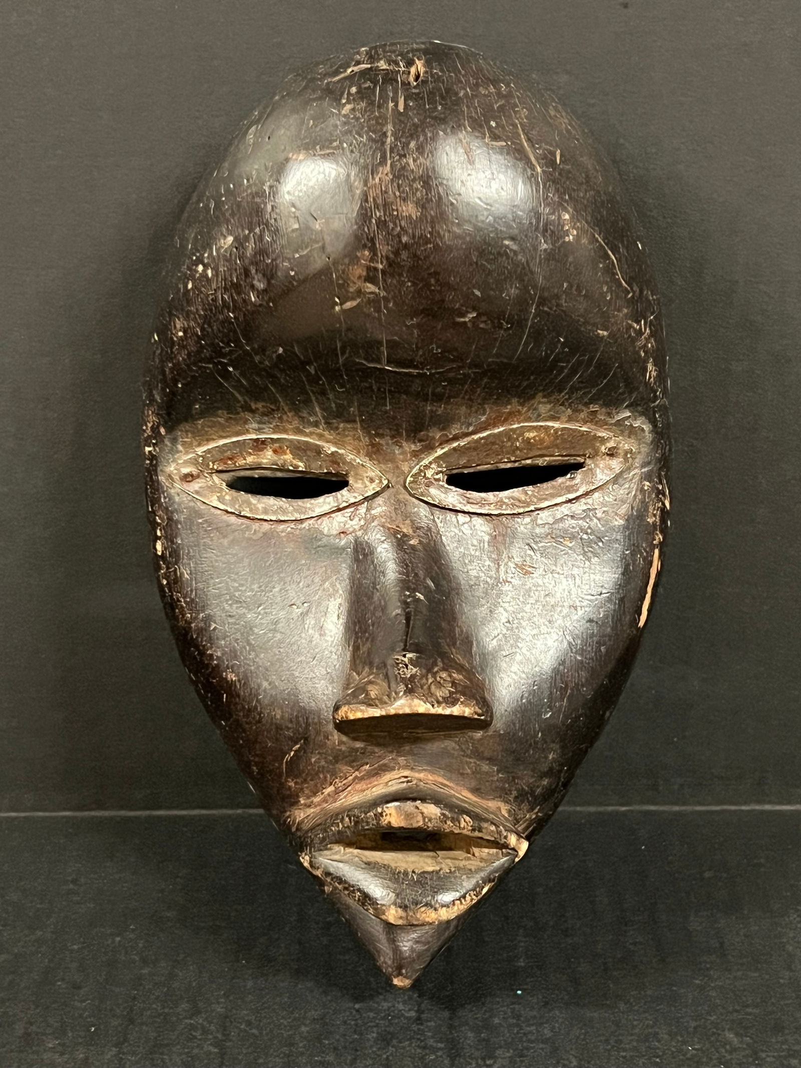 Carved Wood Dan Mask: African Tribal Art Carved Wood Dan Mask. The dimension is 9.5 inches high x 5.75 inches wide. Please be aware that some of the items are vintage, secondhand, old ages, antiques and may have a defects