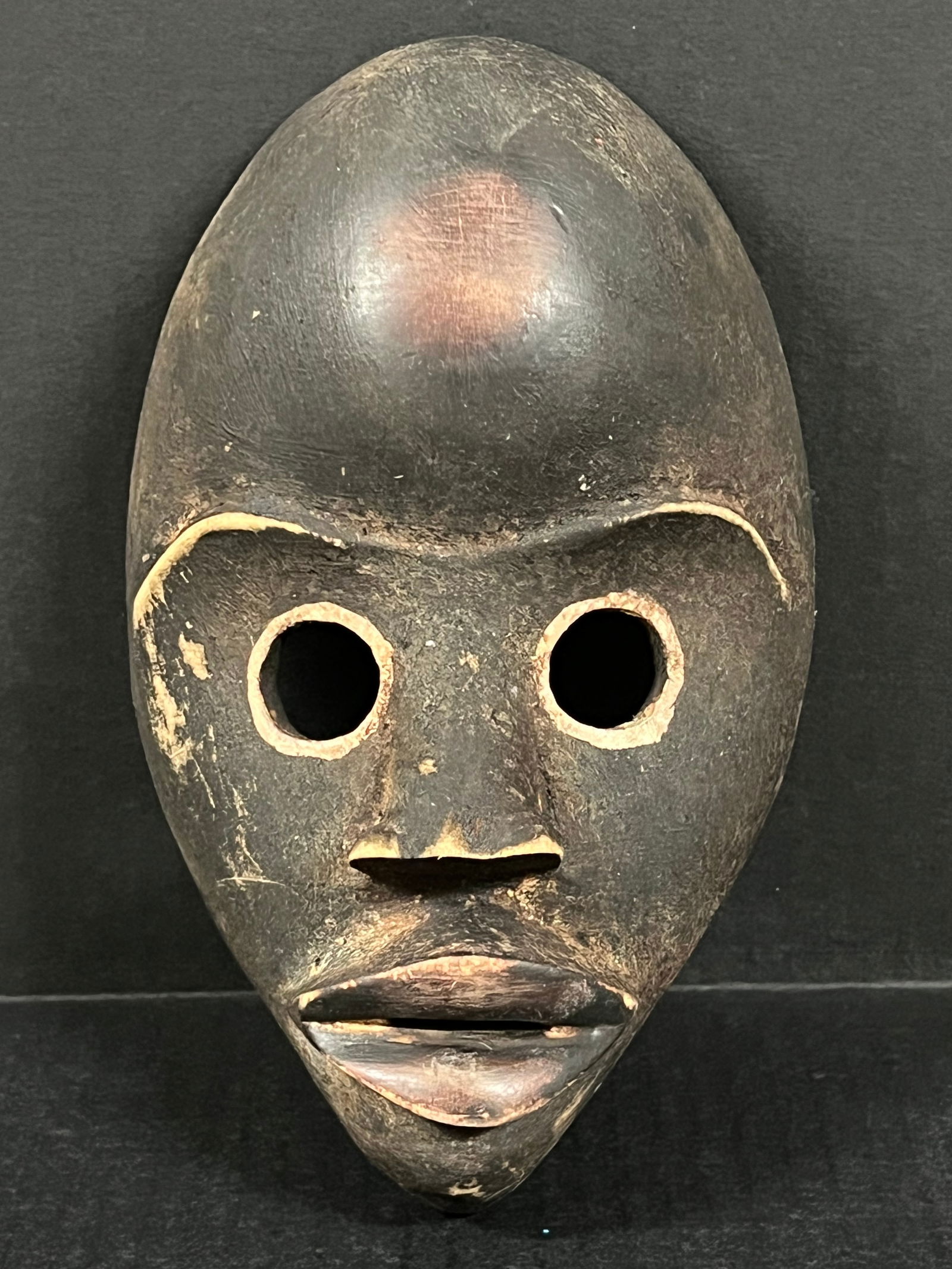 Carved Wood Dan Mask: African Tribal Art Carved Wood Dan Mask. The dimension is 9 inches high x 5.5 inches wide. Please be aware that some of the items are vintage, secondhand, old ages, antiques and may have a defects or