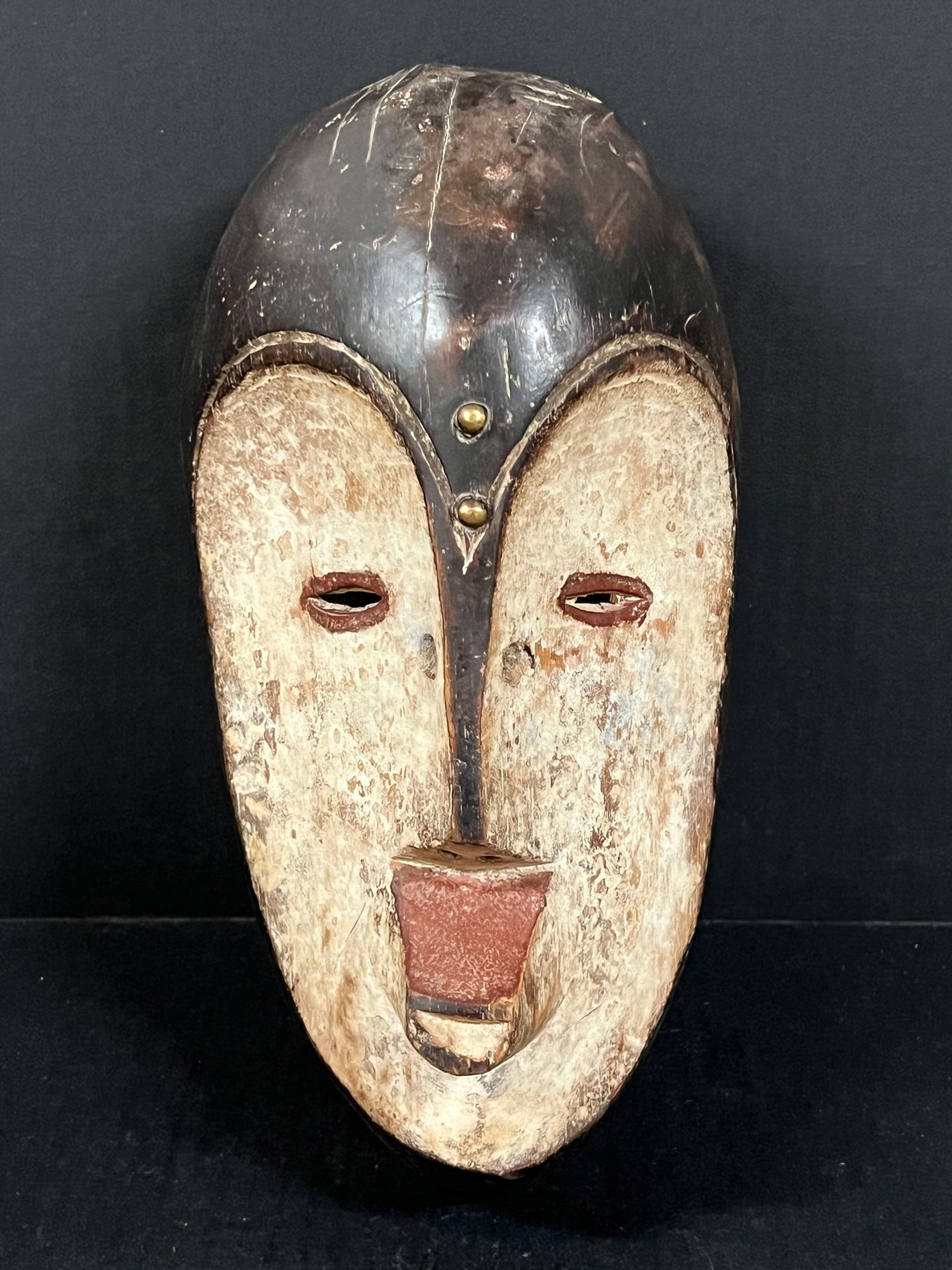 Fang Mask: African Tribal Art Fang Mask. The dimension is 12 inches high x 6.25 inches wide. Please be aware that some of the items are vintage, secondhand, old ages, antiques and may have a defects or sign of a