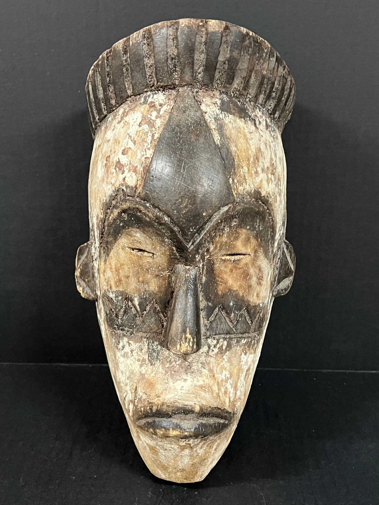 Fang Mask: African Tribal Art Carved Wood Fang Mask. The dimension is 12 inches high x 6.5 inches wide. Please be aware that some of the items are vintage, secondhand, old ages, antiques and may have a defects o