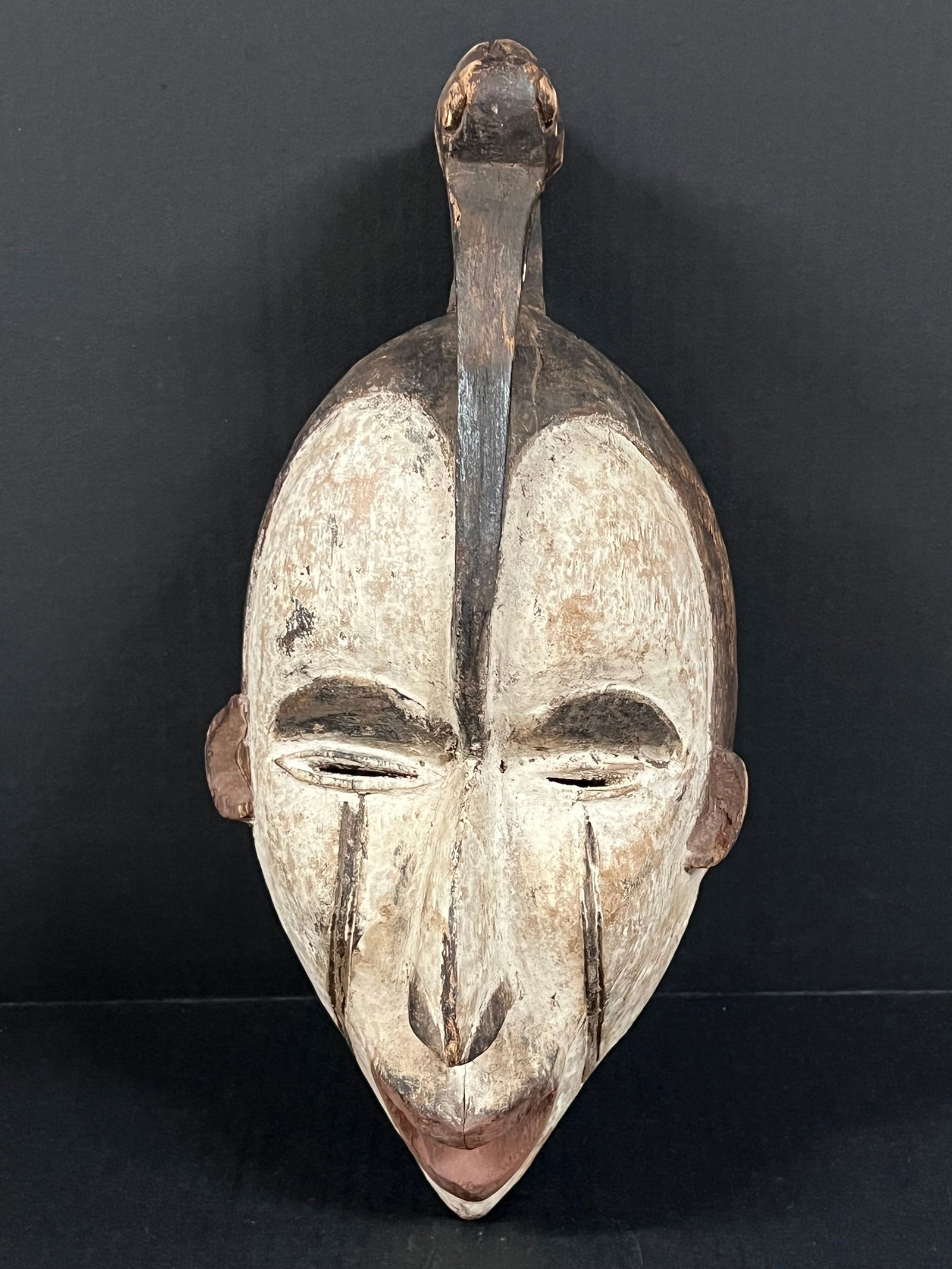 Ibo Mask: African Tribal Art Carved Wood Ibo Mask. The dimension is 16 inches high x 7.5 inches wide. Please be aware that some of the items are vintage, secondhand, old ages, antiques and may have a defects or