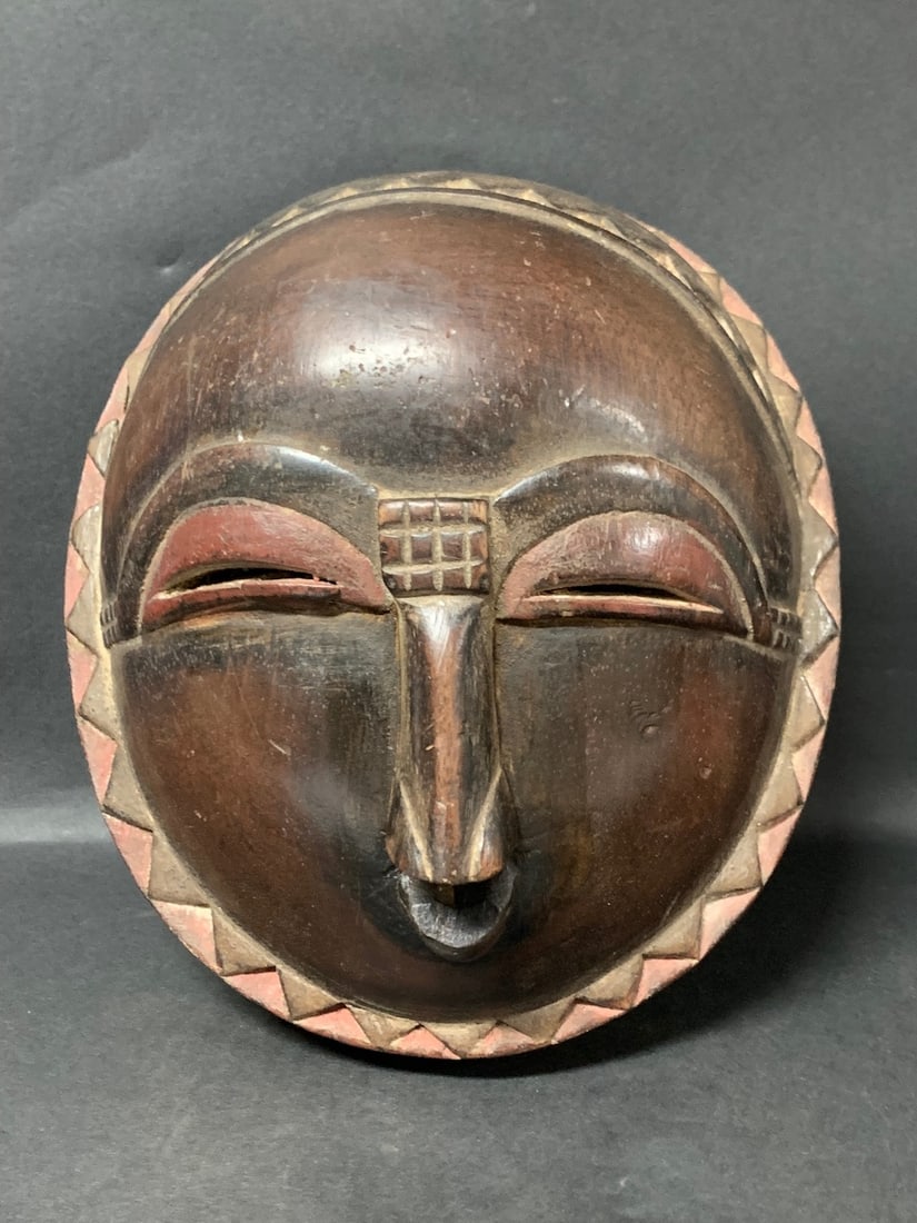 Baule Mask: African Tribal Art Carved Wood Baule Mask. The dimension is 9.5 inches high x 8.5 inches wide. Please be aware that some of the items are vintage, secondhand, old ages, antiques and may have a defects