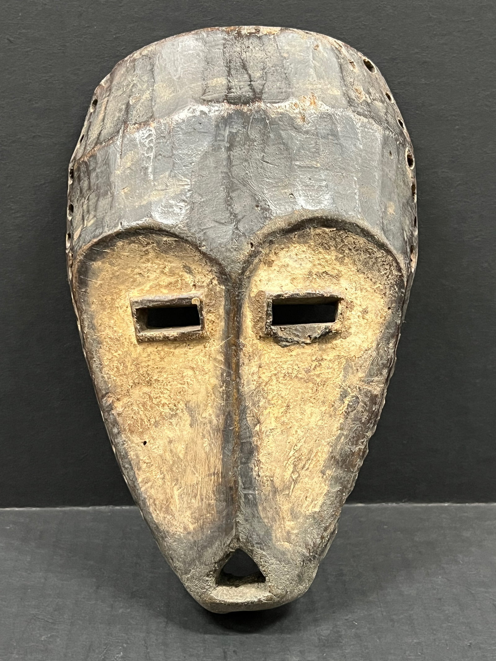 Carved Wood Lega Mask: African Tribal Art Carved Wood Lega Mask. The dimension is 10.25 inches high x 6.5 inches wide. Please be aware that some of the items are vintage, secondhand, old ages, antiques and may have a defect