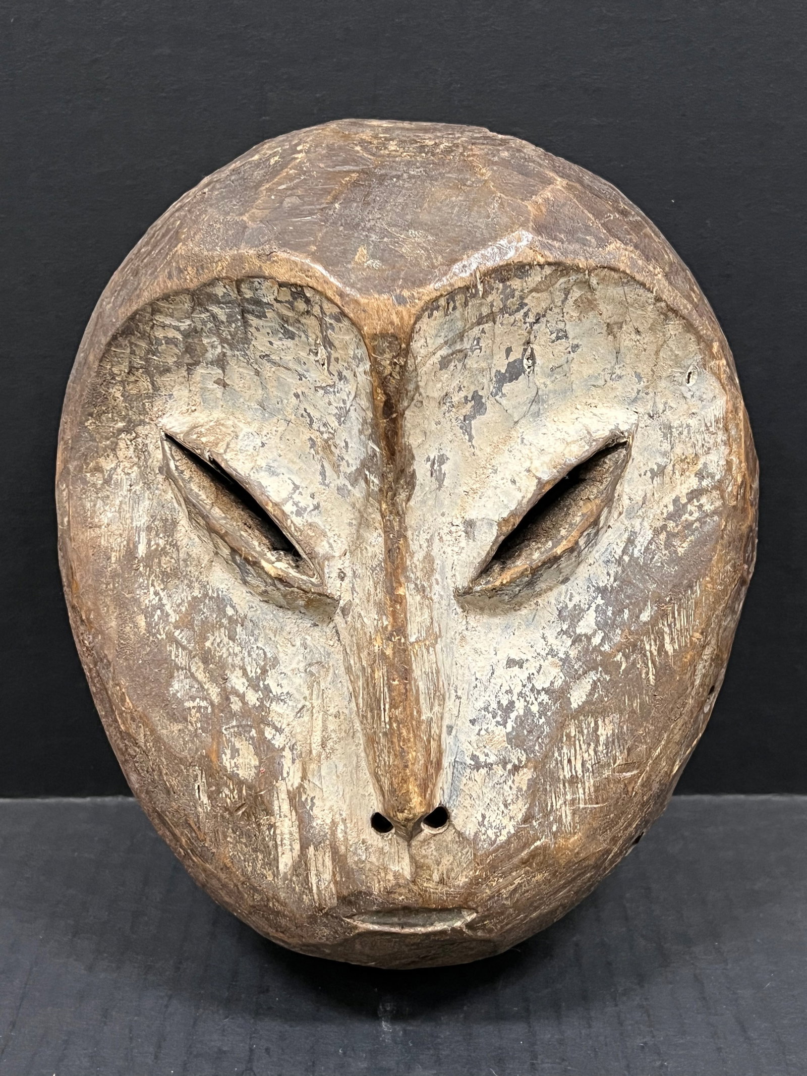 Carved Wood Lega Mask: African Tribal Art Carved Wood Lega Mask. The dimension is 9.5 inches high x 8 inches wide. Please be aware that some of the items are vintage, secondhand, old ages, antiques and may have a defects or