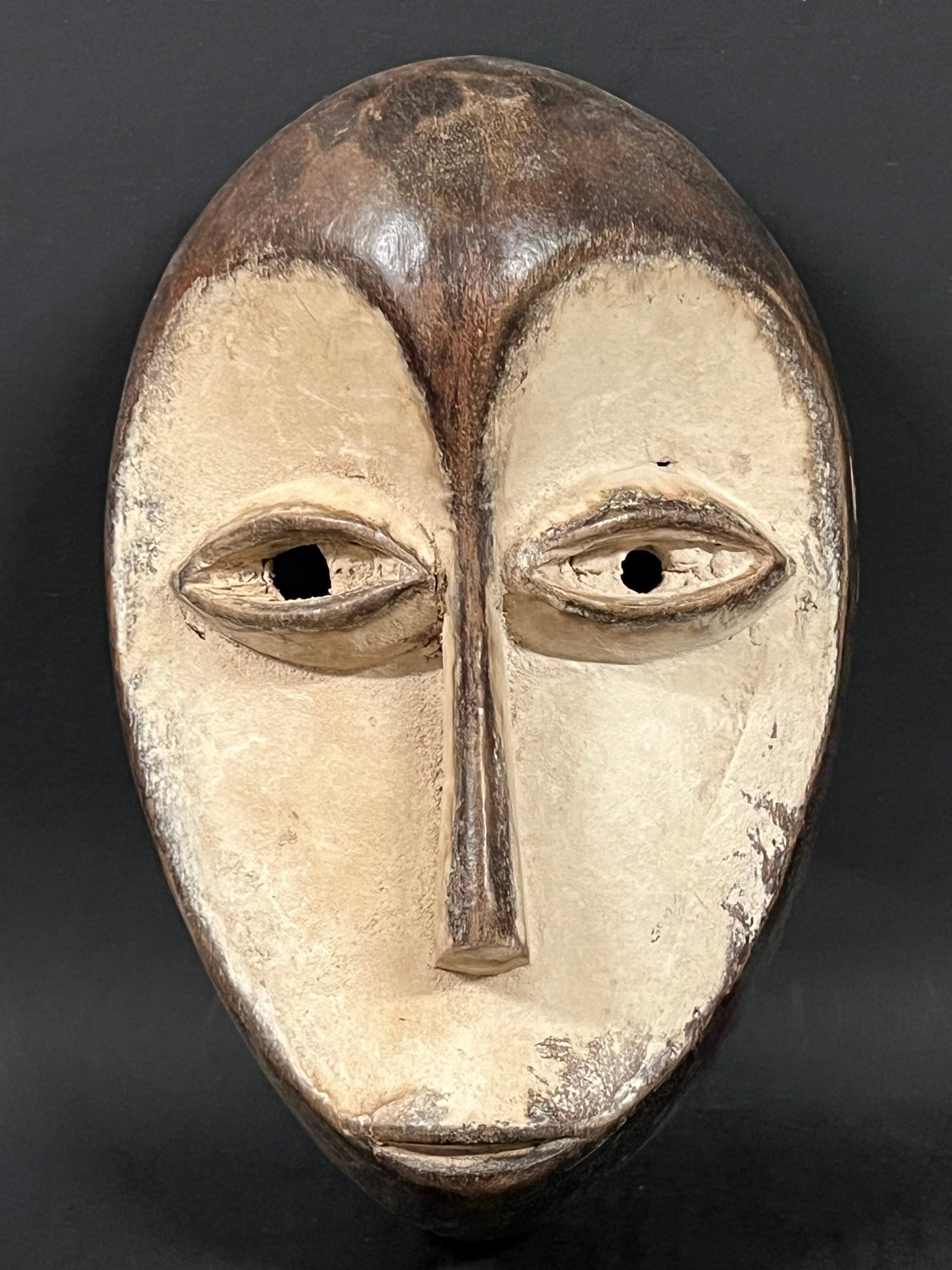 Carved Wood Lega Mask: African Tribal Art Carved Wood Lega Mask. The dimension is 9.5 inches high x 6 inches wide. Please be aware that some of the items are vintage, secondhand, old ages, antiques and may have a defects or