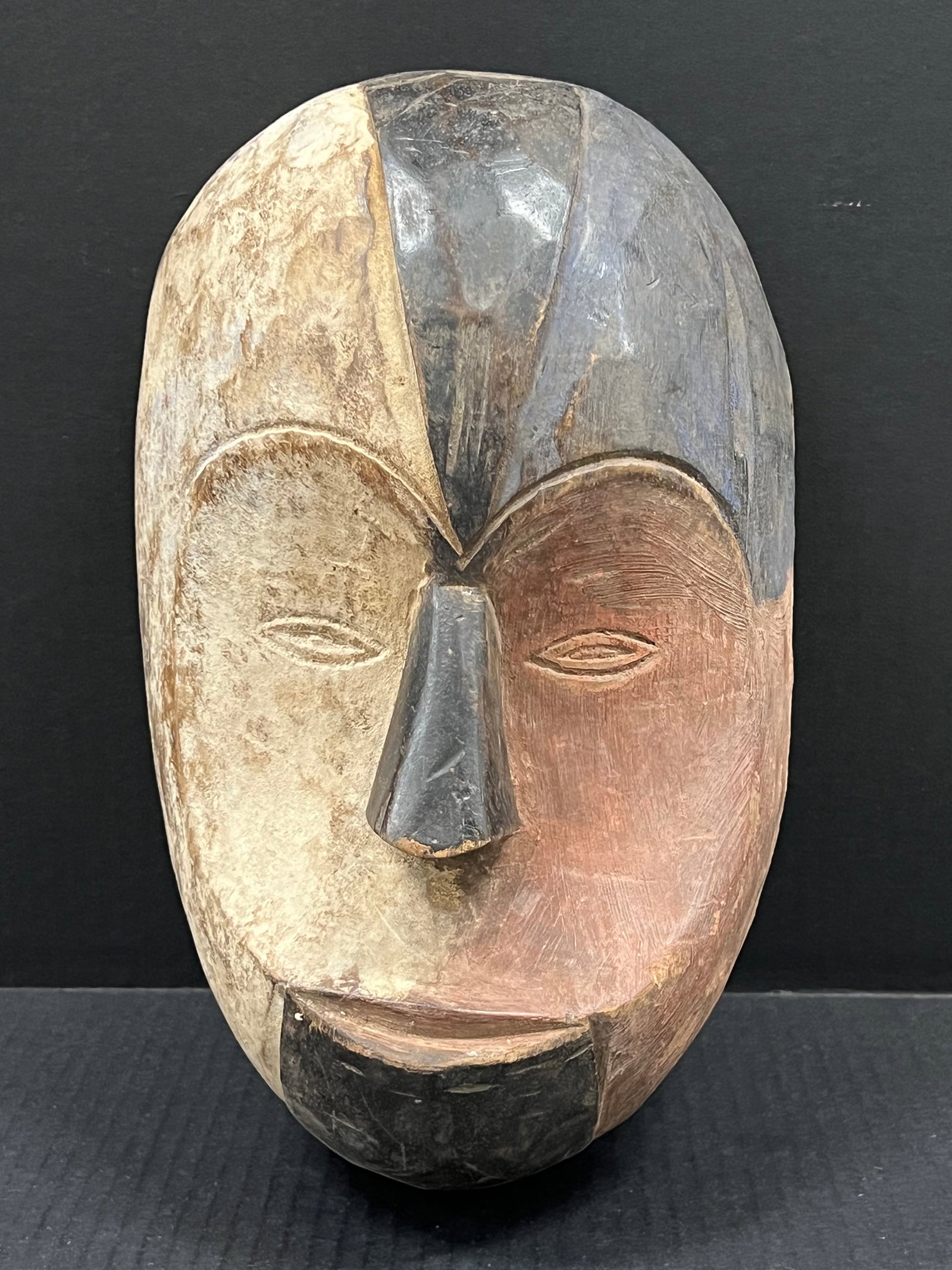 Fang Mask: African Art Carved Wood Fang Mask. The dimension is 13 inches high x 9 inches wide including base. Please be aware that some of the items are vintage, secondhand, old ages, antiques and may have a def