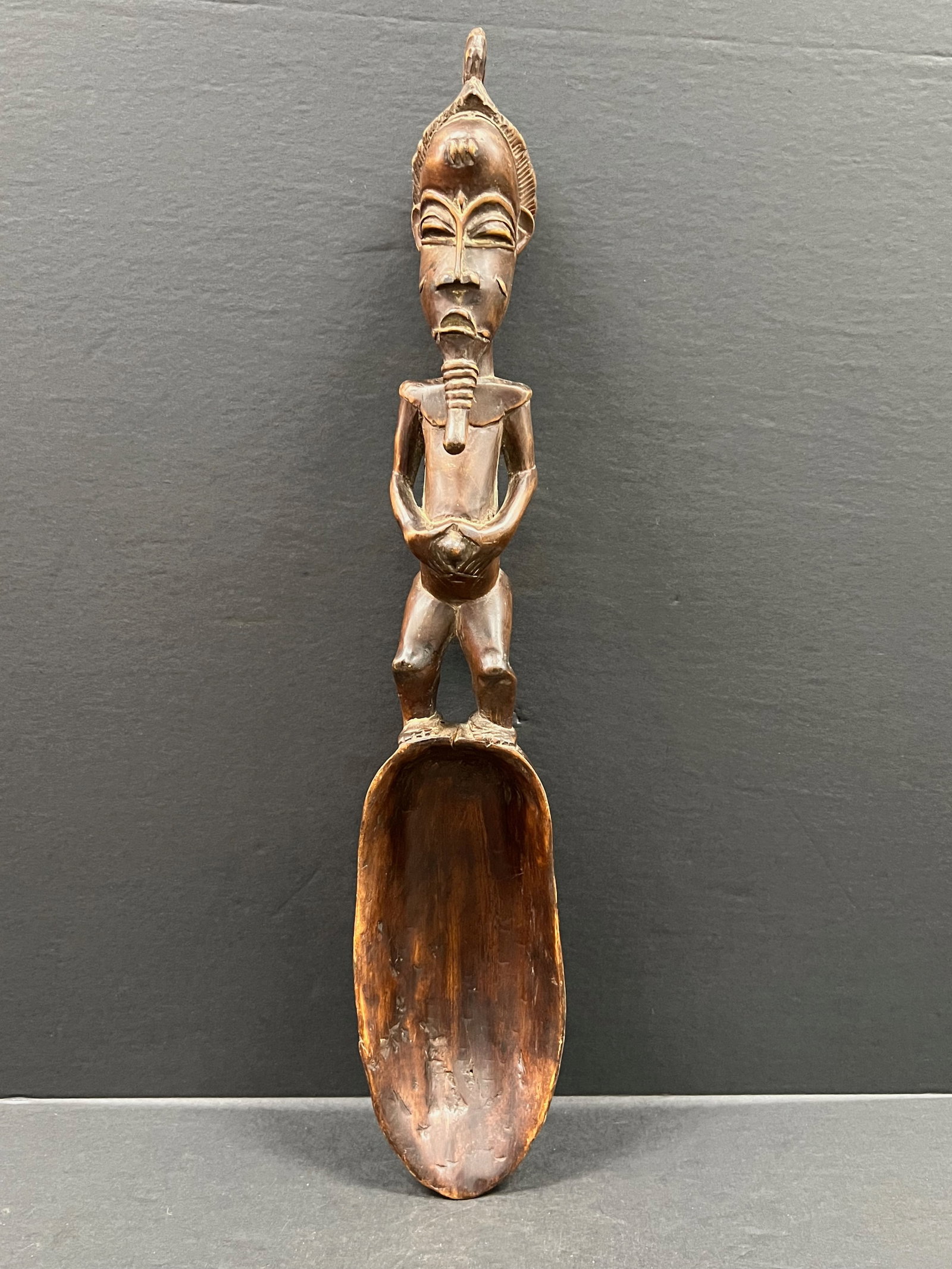 Baule Spoon: African Tribal Art Baule Spoon. The dimension is 19.5 inches high x 4 inches wide. Please be aware that some of the items are vintage, secondhand, old ages, antiques and may have a defects or sign of