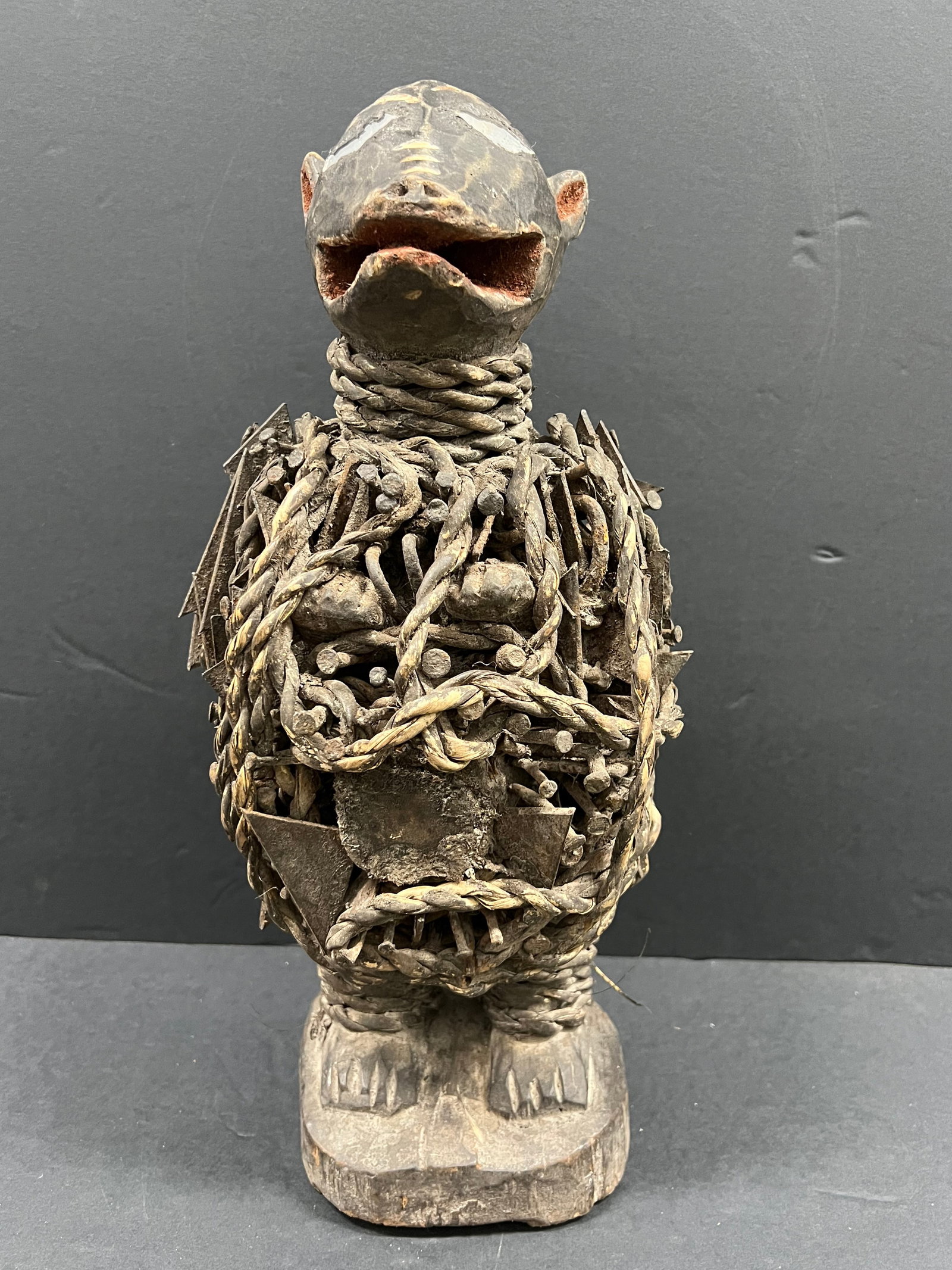 Carved Wood Bacongo Nail Dog Fetish Statue: African Tribal Art Carved Wood Bacongo Nail Dog Fetish Statue. The dimension is 16.5 inches high x 7.5 inches wide. Please be aware that some of the items are vintage, secondhand, old ages, antiques