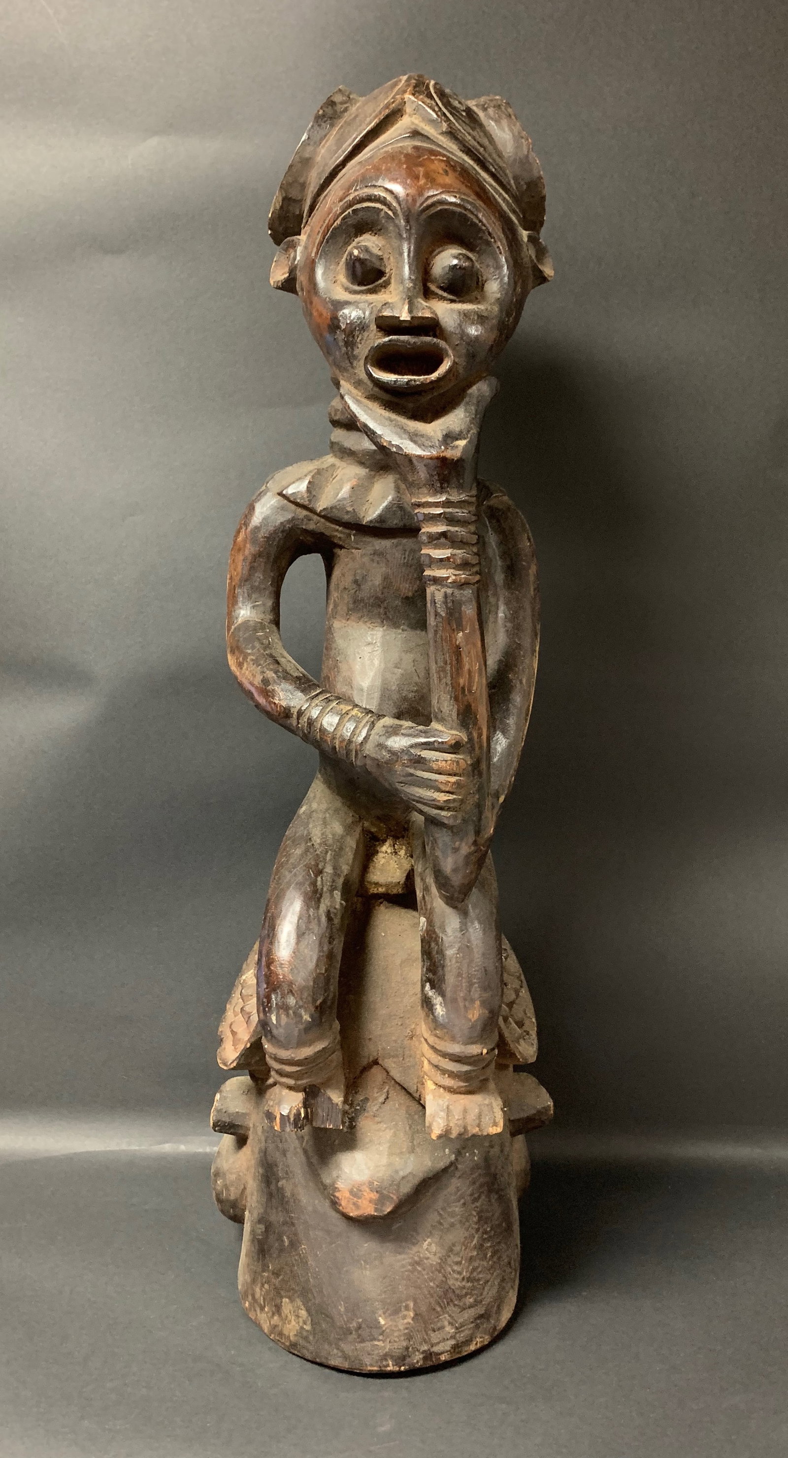 Carved Wood Bamileke Statue: African Tribal Art Carved Wood Bamileke Statue. The dimension is 28 inches high x 8 inches wide. Please be aware that some of the items are vintage, secondhand, old ages, antiques and may have a defec