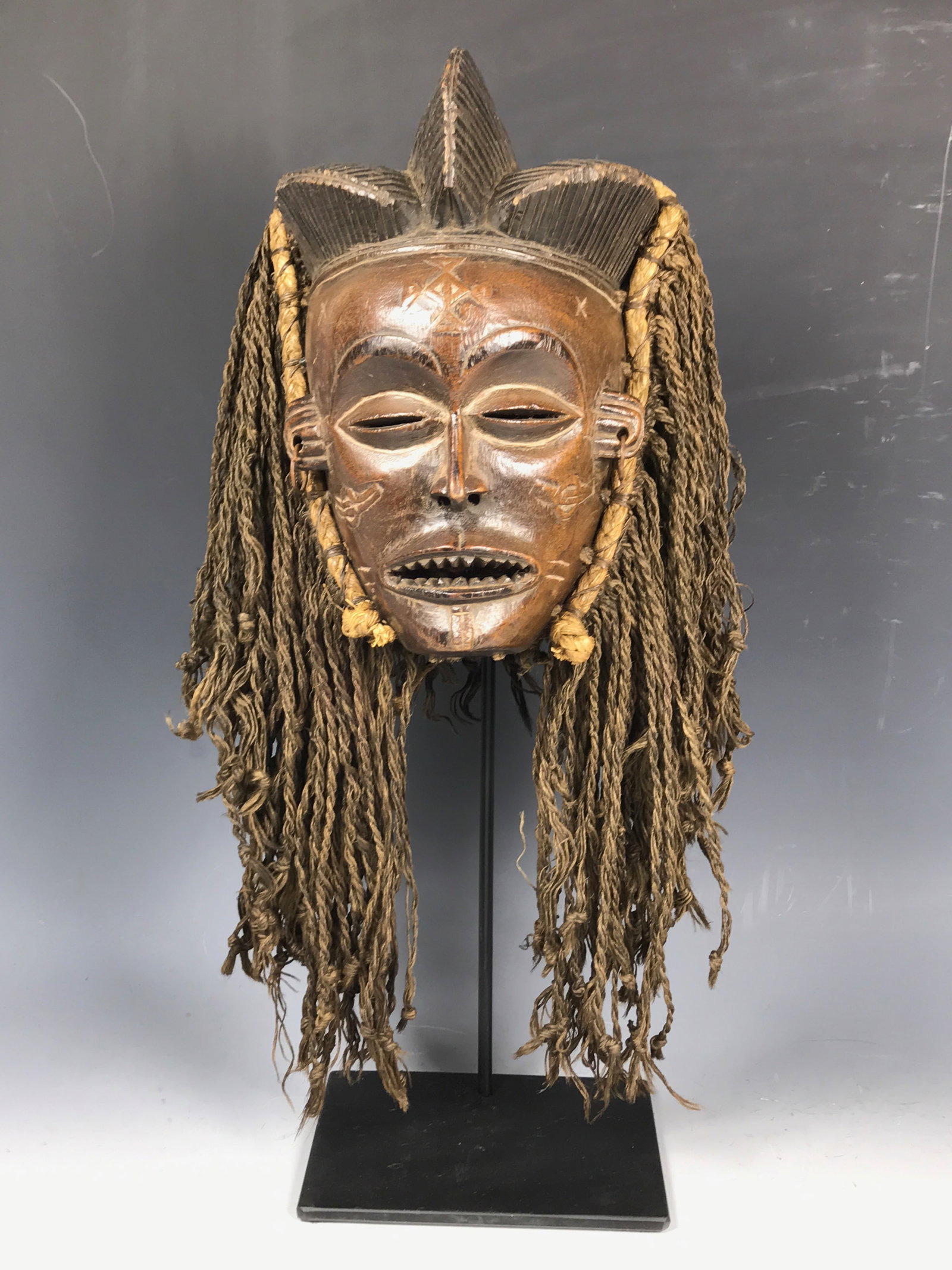 Carved Wood Chokwe Mask with Display Stand: African Tribal Art Carved Wood Chokwe Mask with Display Stand. The dimension is 9.5 inches high x 6 inches wide. Please be aware that some of the items are vintage, secondhand, old ages, antiques and