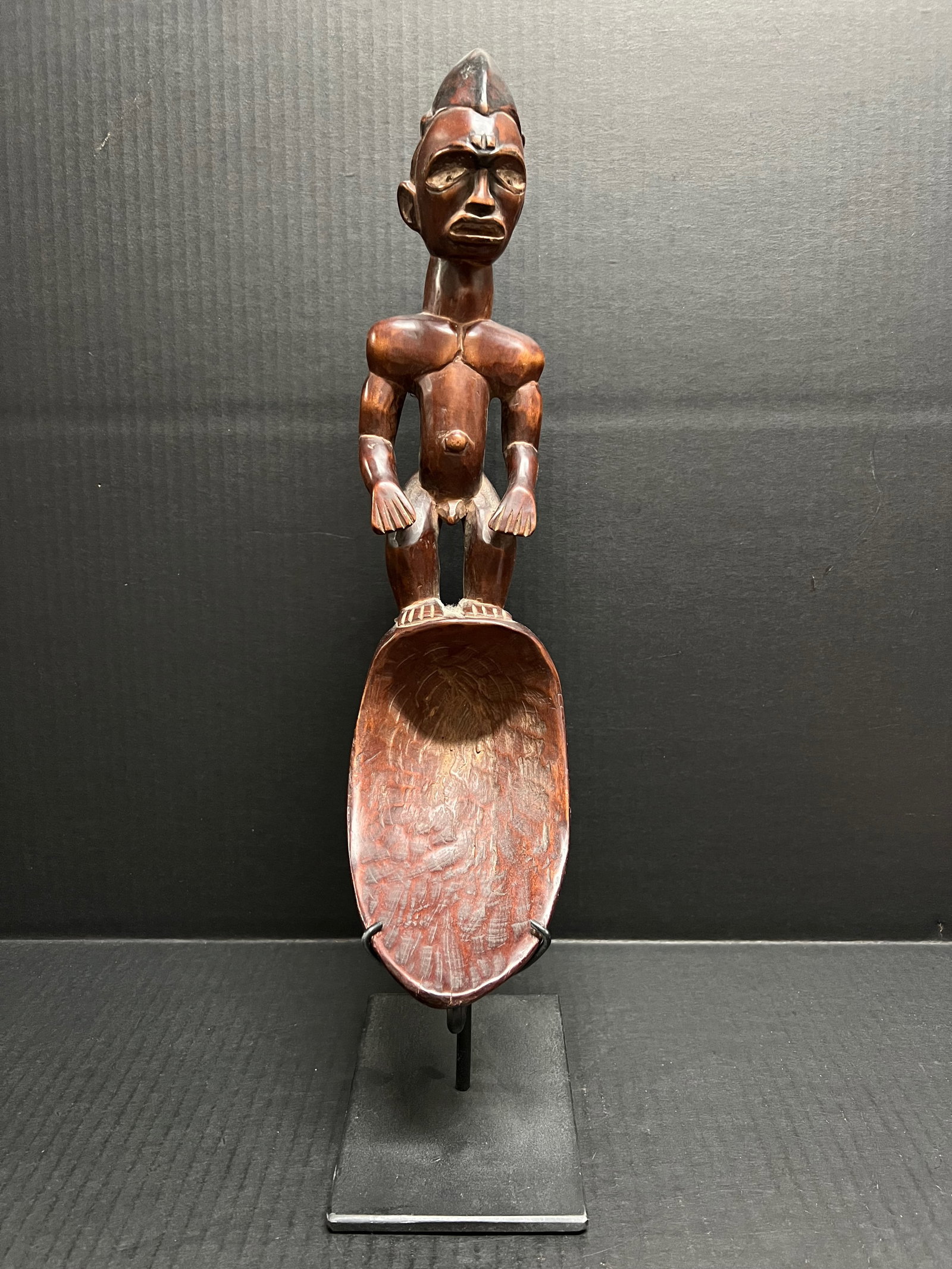Carved Wood Bacongo Spoon with Display Stand: African Tribal Art Carved Wood Bacongo Spoon With Display Stand. The dimension is 18.5 inches high x 4 inches wide. Please be aware that some of the items are vintage, secondhand, old ages, antiques