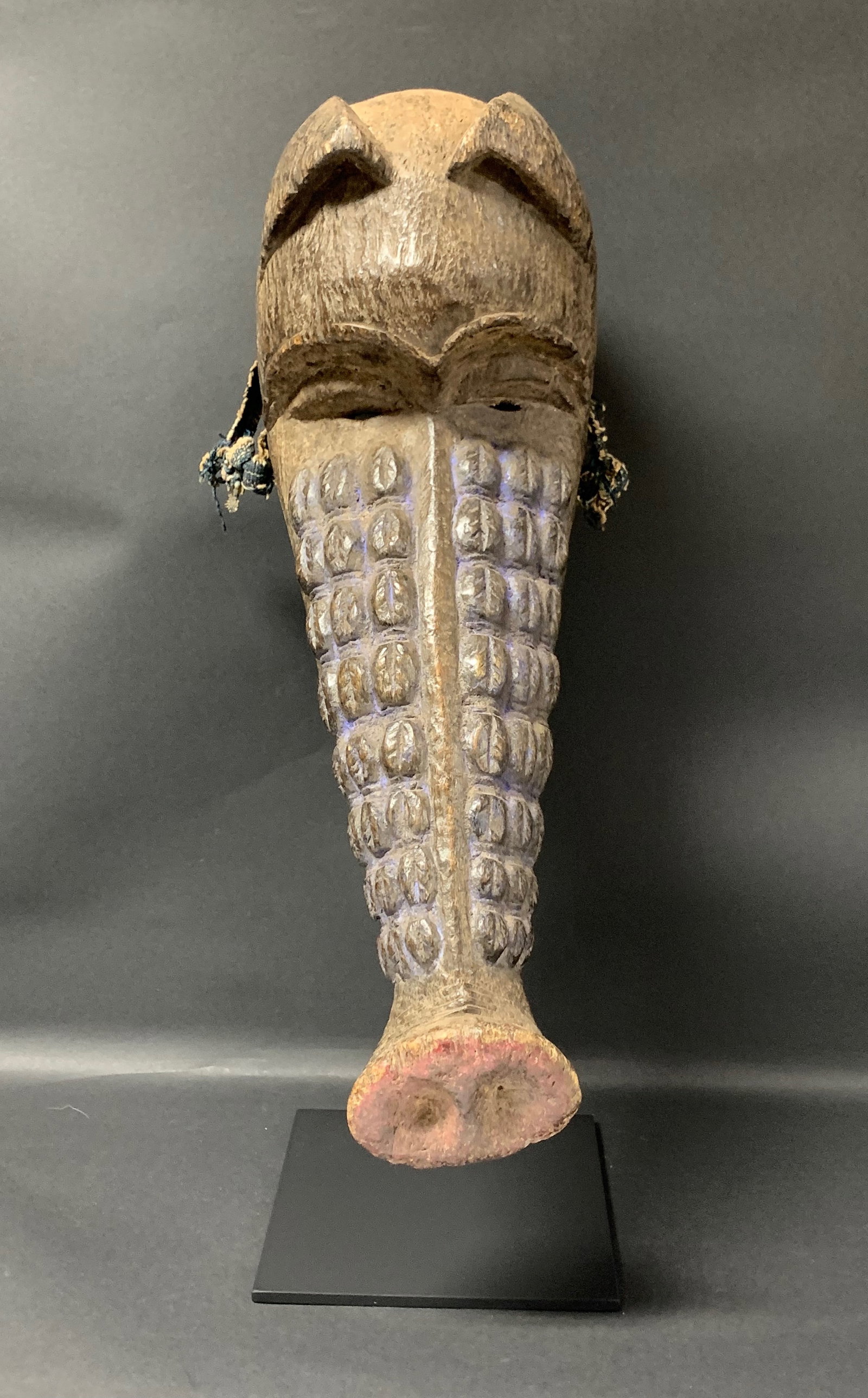 Carved Wood Pig Ngulu Mask With Display Stand: African Tribal Art Carved Wood Pig Ngulu Mask with Display Stand. The dimension is 23 inches high x 6.5 inches wide. Please be aware that some of the items are vintage, secondhand, old ages, antiques