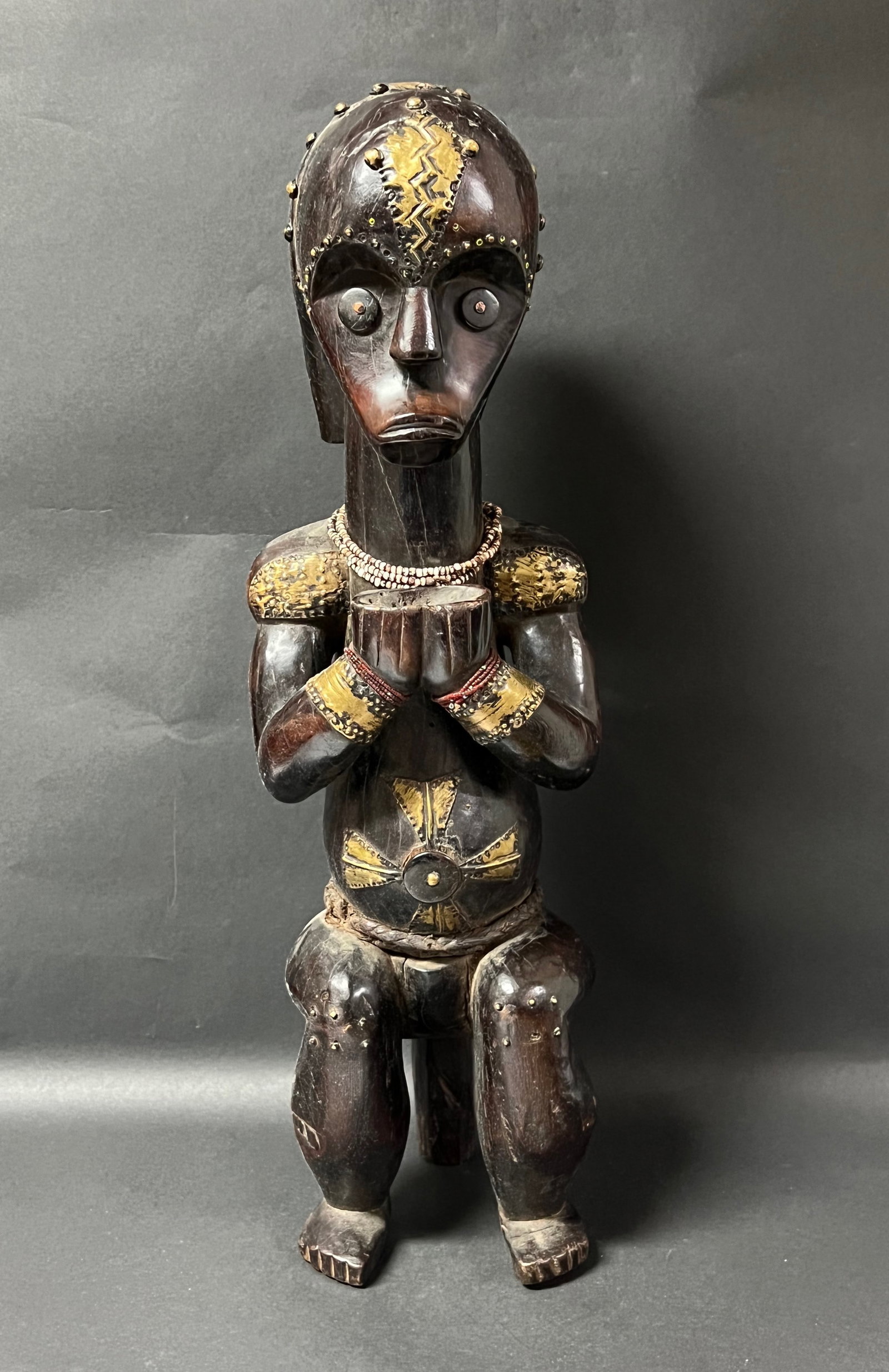 Carved Wood Fang Statue: African Tribal Art Carved Wood Fang Statue. The dimension is 25 inches high x 7.5 inches wide. Please be aware that some of the items are vintage, secondhand, old ages, antiques and may have a
