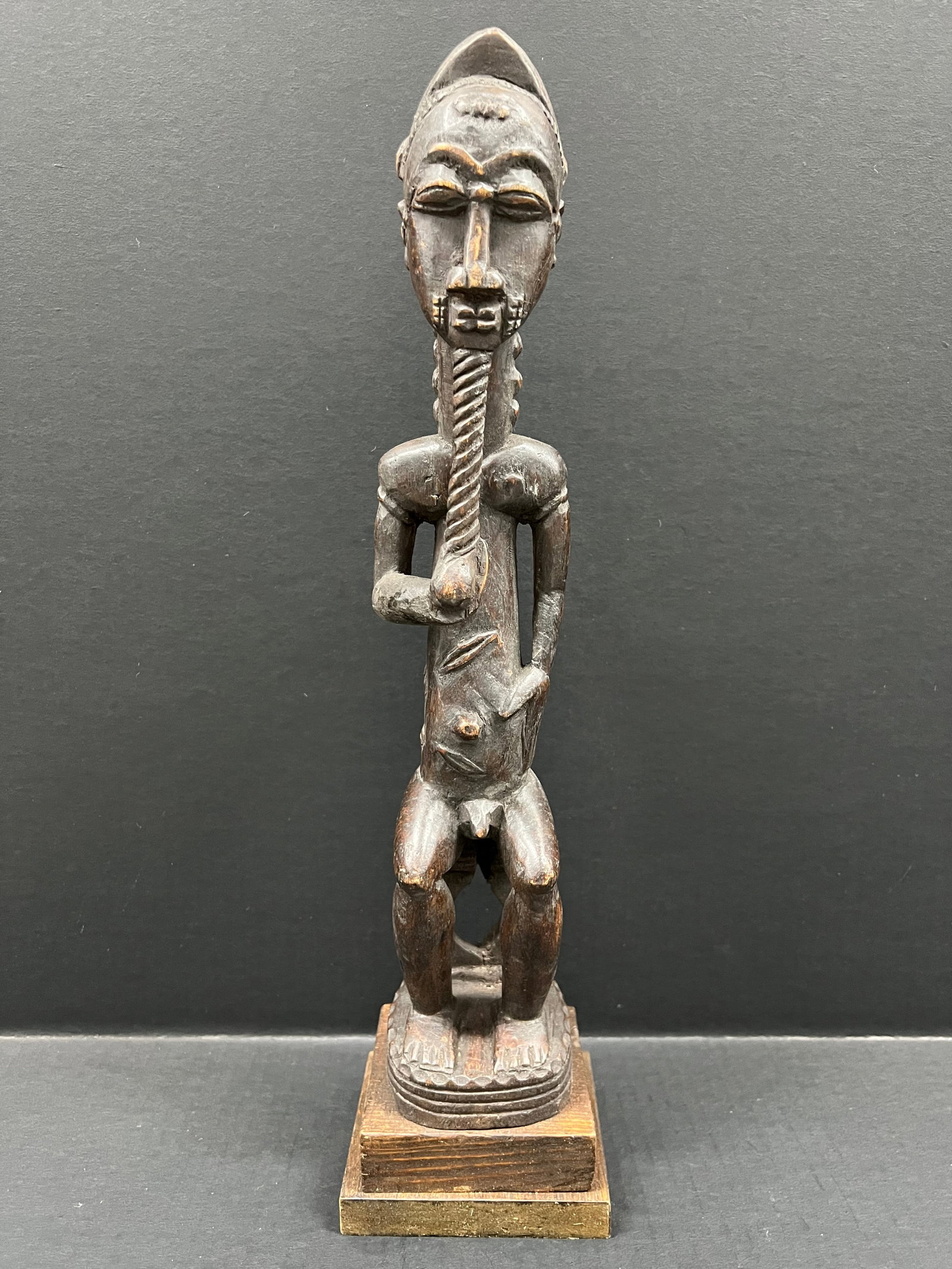 Carved Wood Baule Statue: African Tribal Art Carved Wood Baule Statue. The dimension is 19 inches high x 3.5 inches wide. Please be aware that some of the items are vintage, secondhand, old ages, antiques and may have a