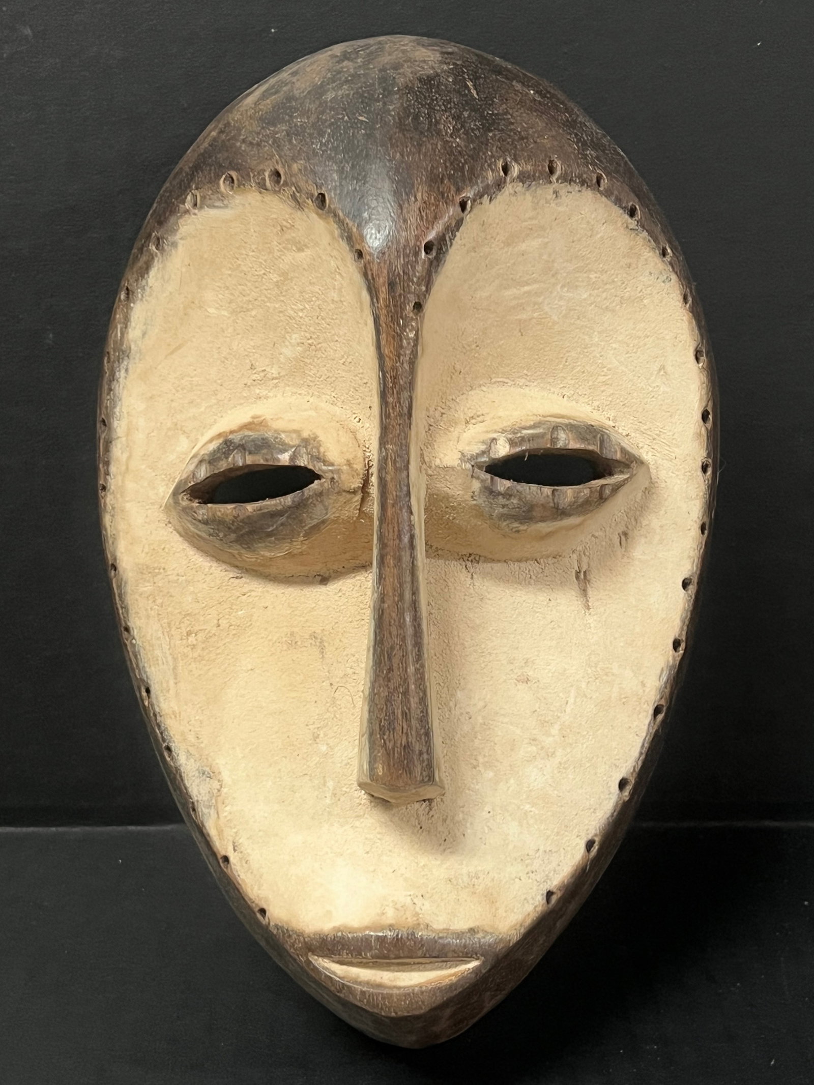 Lega Mask: African Tribal Art Lega Mask. The dimension is 9.5 inches high x 6.25 inches wide. Please be aware that some of the items are vintage, secondhand, old ages, antiques and may have a defects or sign of
