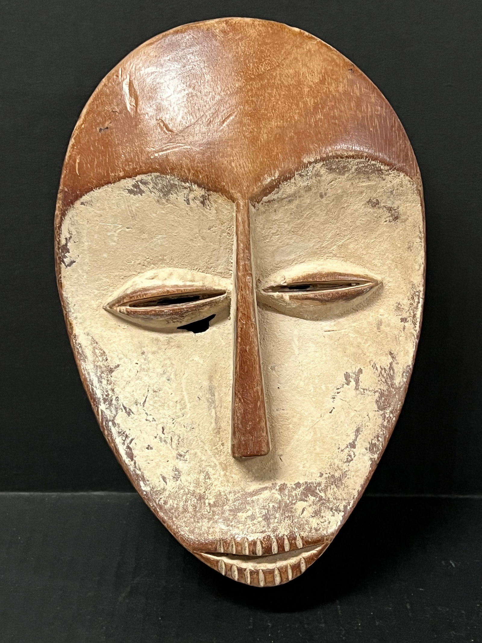 Lega Mask: African Tribal Art Lega Mask. The dimension is 10 inches high x 6.75 inches wide. Please be aware that some of the items are vintage, secondhand, old ages, antiques and may have a defects or sign of a
