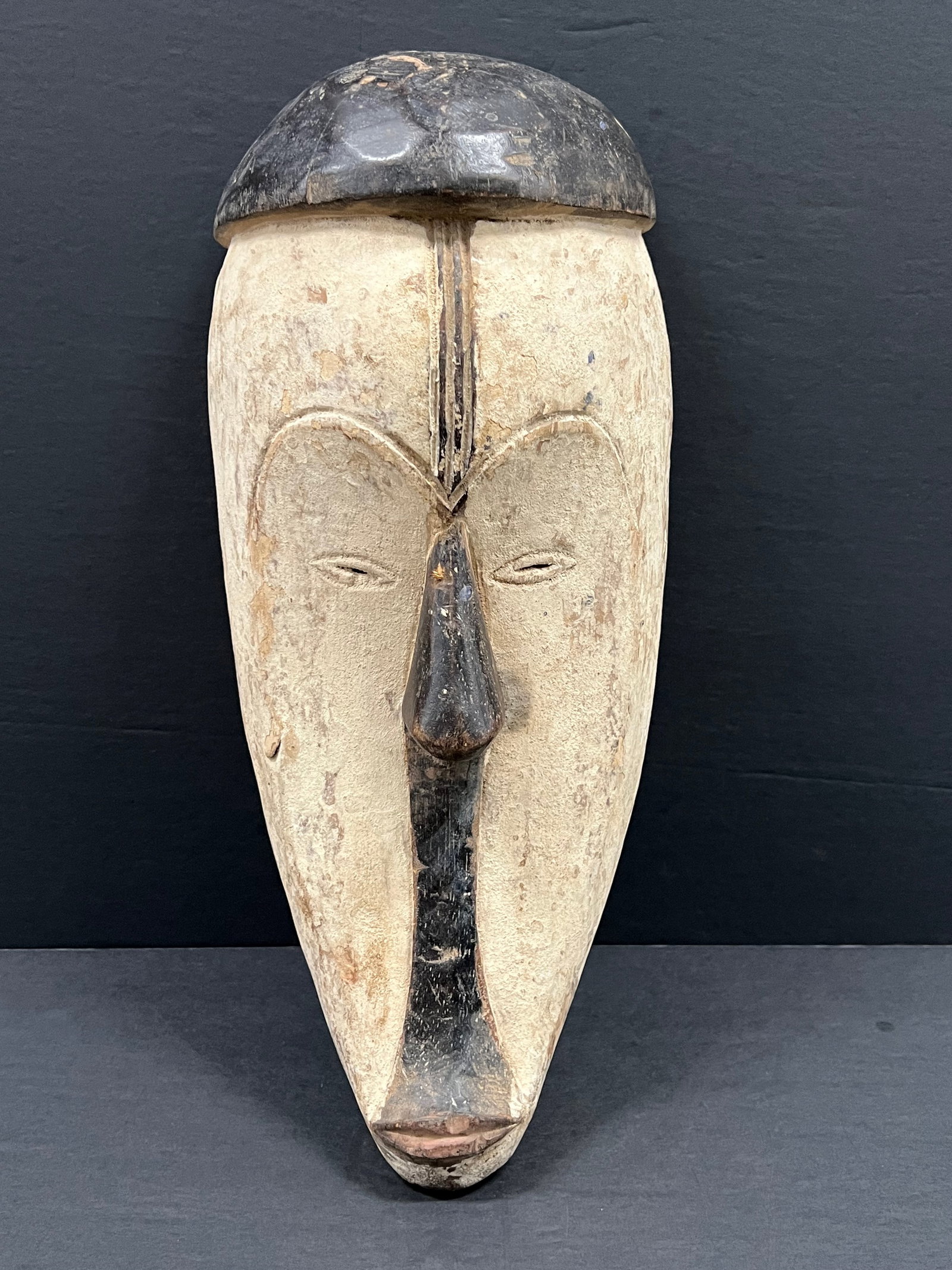 Fang Mask: African Tribal Art Carved Wood Fang Mask. The dimension is 17.5 inches high x 8 inches . Please be aware that some of the items are vintage, secondhand, old ages, antiques and may have a defects or si