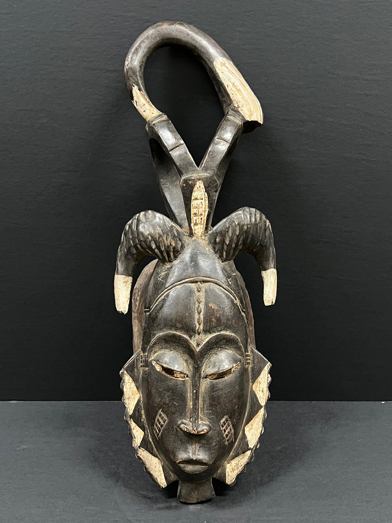 Baule Mask: African Tribal Art Carved Wood Baule Mask. The dimension is 15 inches high x 6 inches . Please be aware that some of the items are vintage, secondhand, old ages, antiques and may have a defects or sig