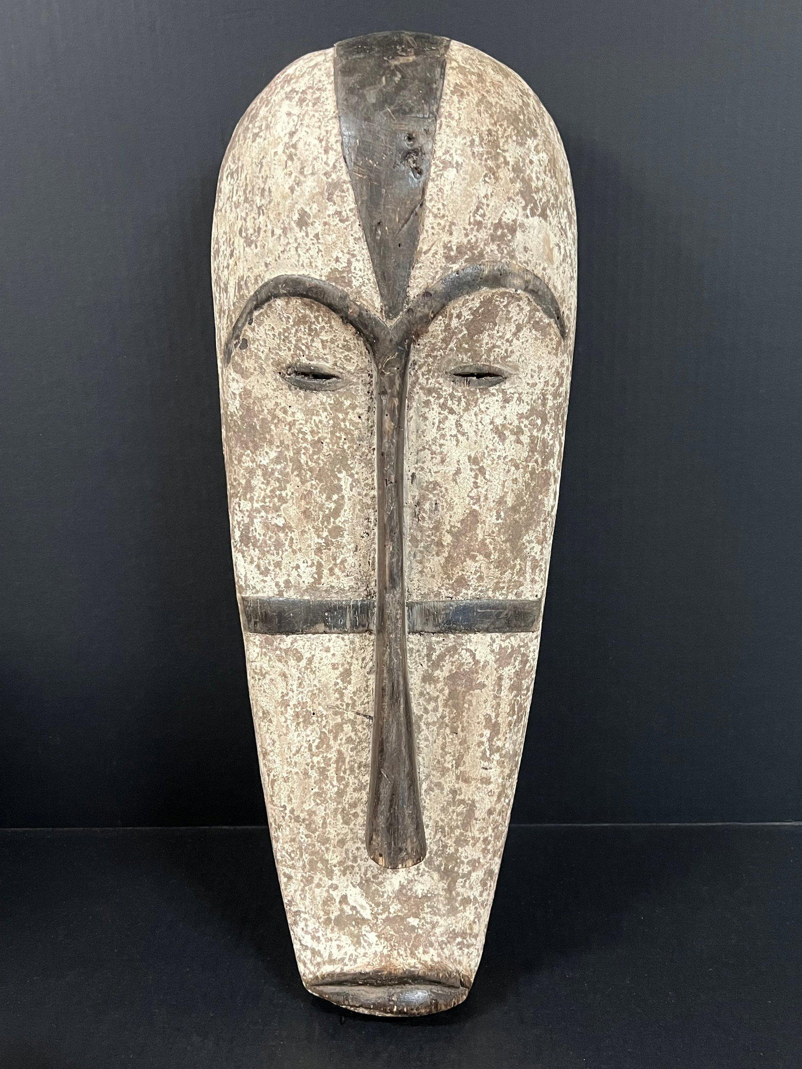 Carved Wood Fang Mask: African Tribal Art Carved Wood Fang Mask. The dimension is 22 inches high x 9 inches wide. Please be aware that some of the items are vintage, secondhand, old ages, antiques and may have a defects or 
