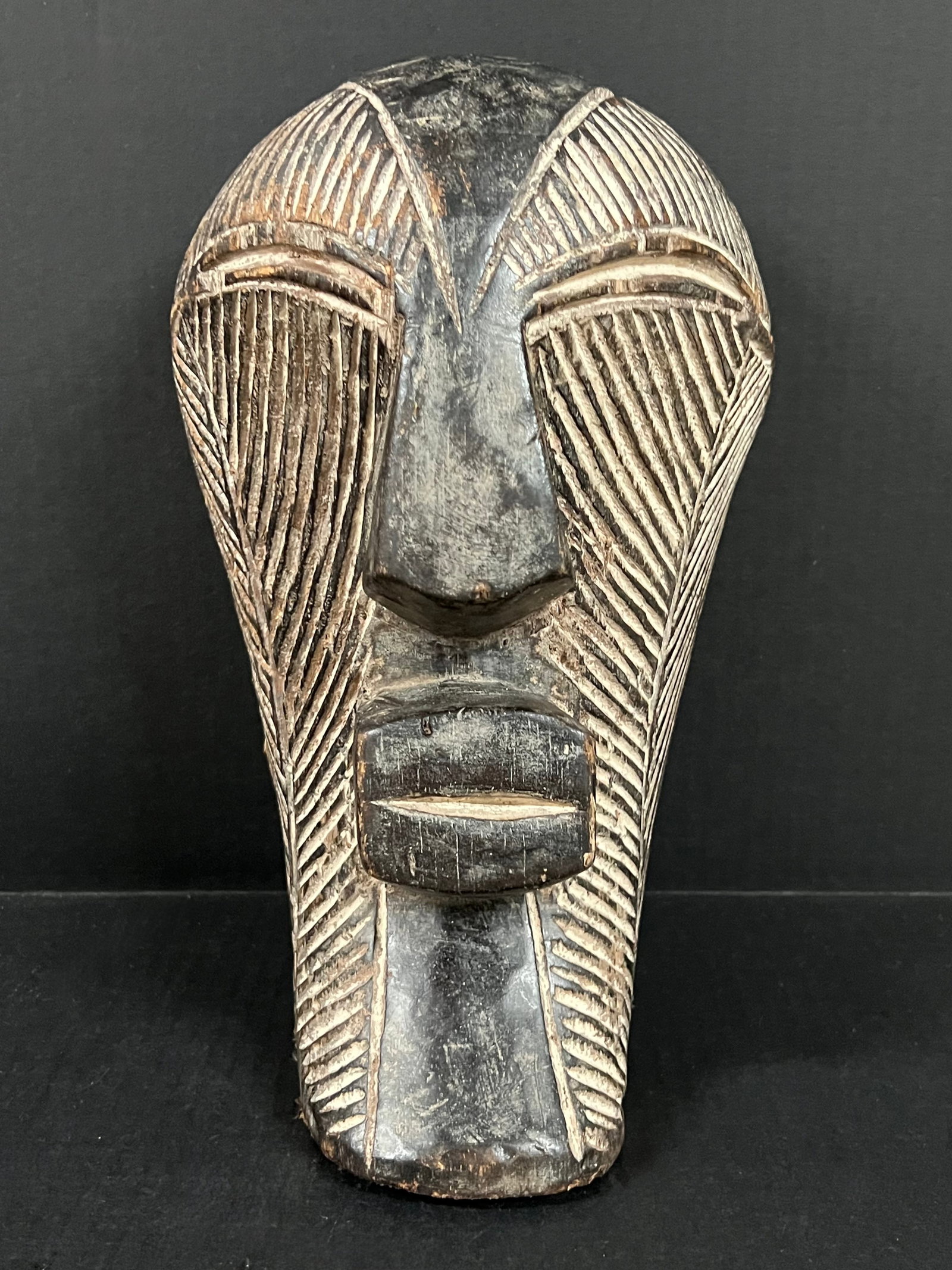 Carved Wood Songye Mask: African Tribal Art Carved Wood Songye Mask. The dimension is 13 inches high x 8 inches wide. Please be aware that some of the items are vintage, secondhand, old ages, antiques and may have a defects o