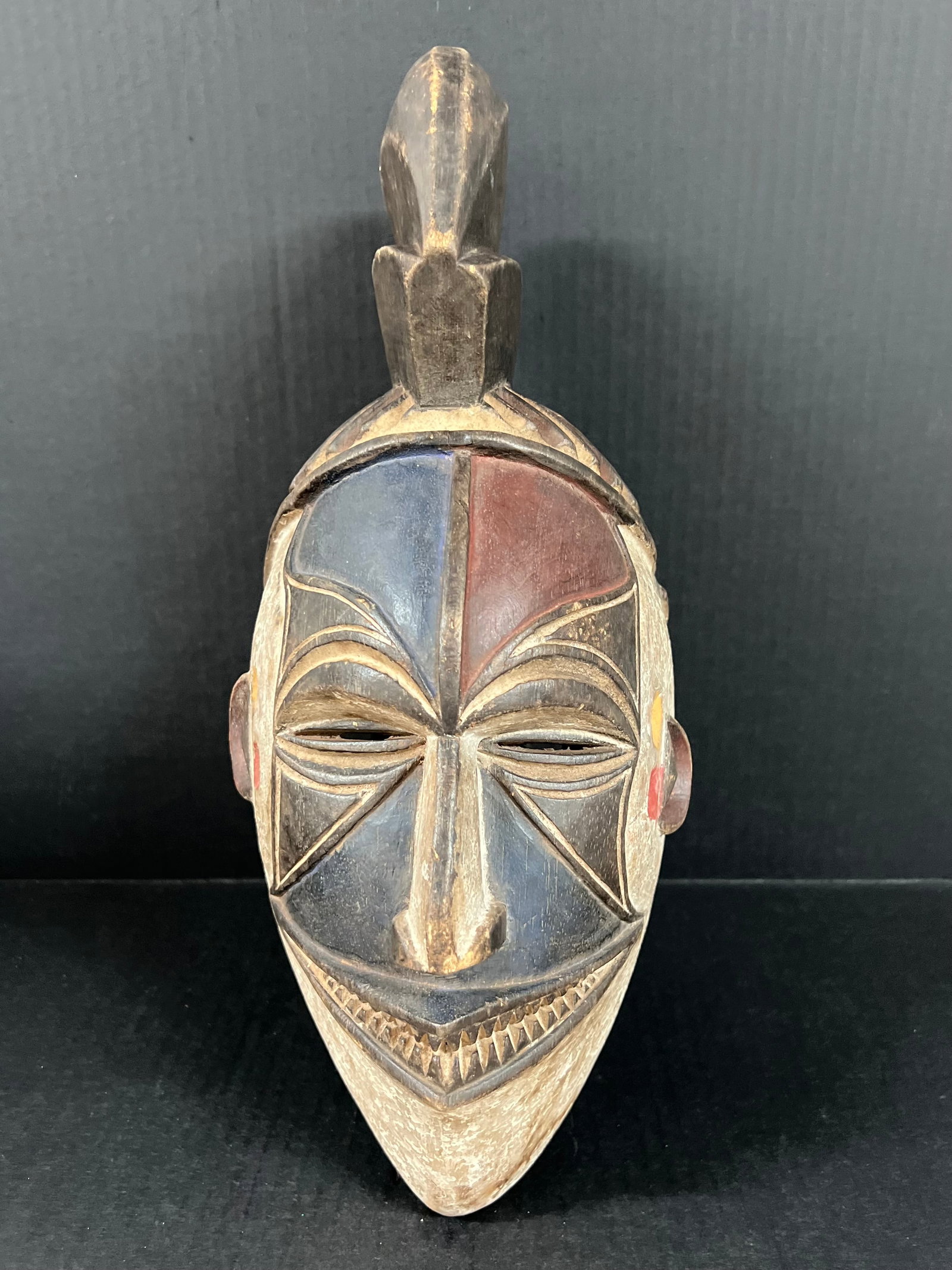 Carved Wood Ibo Mask: African Tribal Art Carved Wood Ibo Mask. The dimension is.16 inches high x 7 inches wide. Please be aware that some of the items are vintage, secondhand, old ages, antiques and may have a defects or s