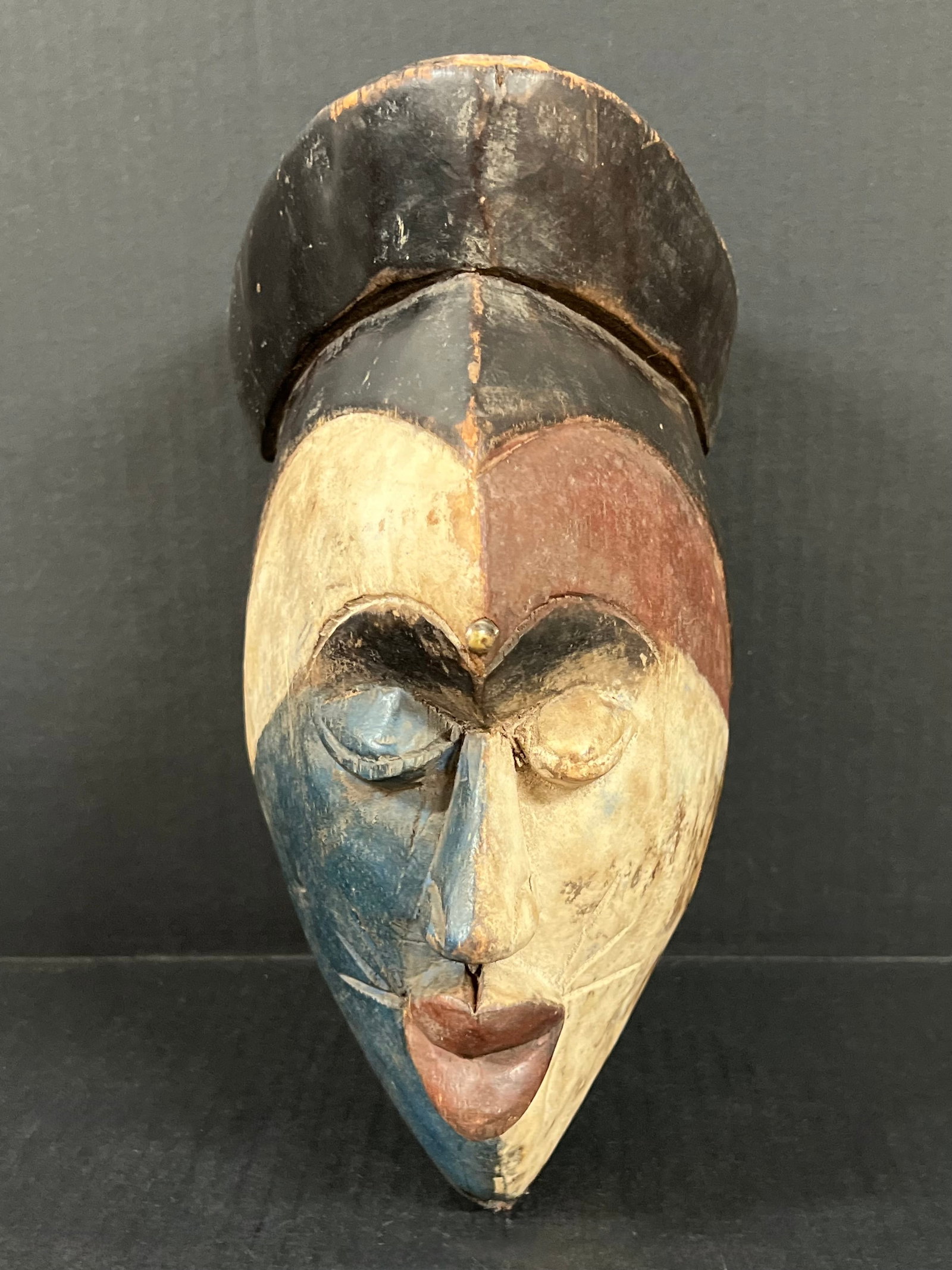 Carved Wood Ibo Mask: African Tribal Art Carved Wood Ibo Mask. The dimension is 11.5 inches high x 6.25 inches wide. Please be aware that some of the items are vintage, secondhand, old ages, antiques and may have a defects