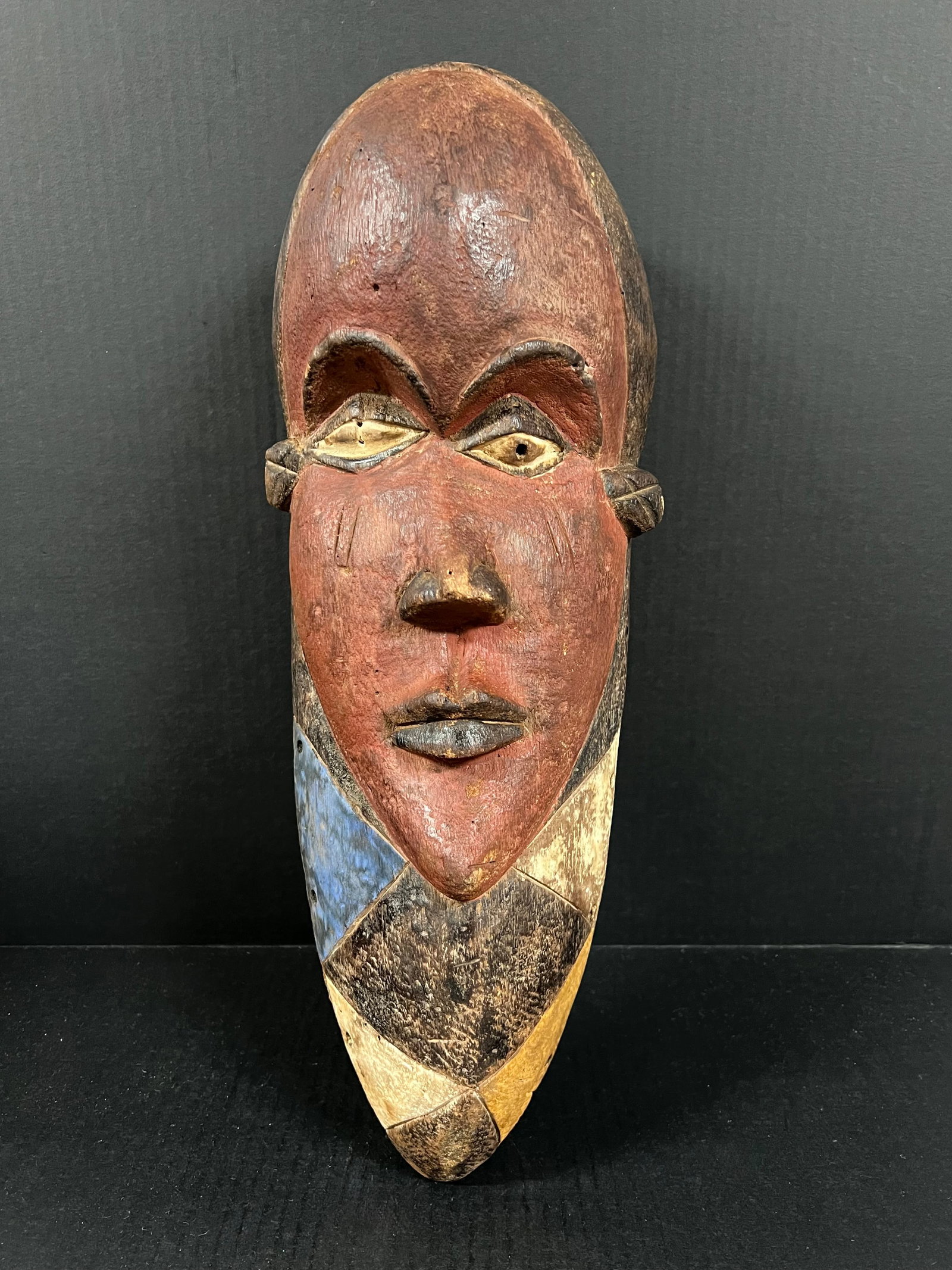 Carved Wood Bacongo Mask: African Tribal Art Carved Wood Bacongo Mask. The dimension is 19 inches high x 7.5 inches wide. Please be aware that some of the items are vintage, secondhand, old ages, antiques and may have a defect