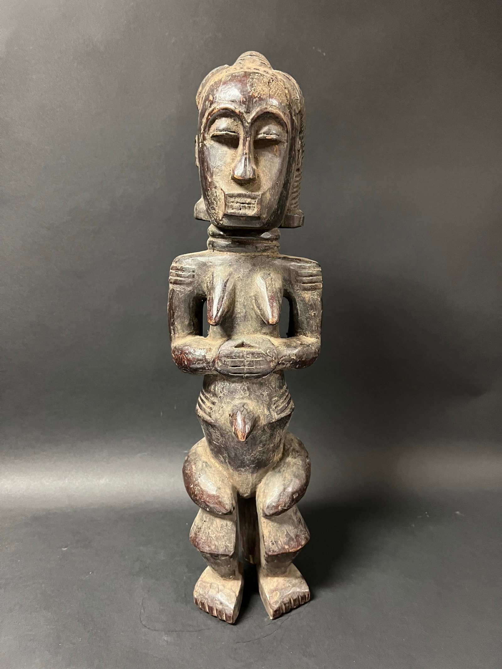 Carved Wood Fang Statue: African Tribal Art Carved Wood Fang Statue. The dimension is 19.5 inches high x 5.5 inches wide. Please be aware that some of the items are vintage, secondhand, old ages, antiques and may have a defec