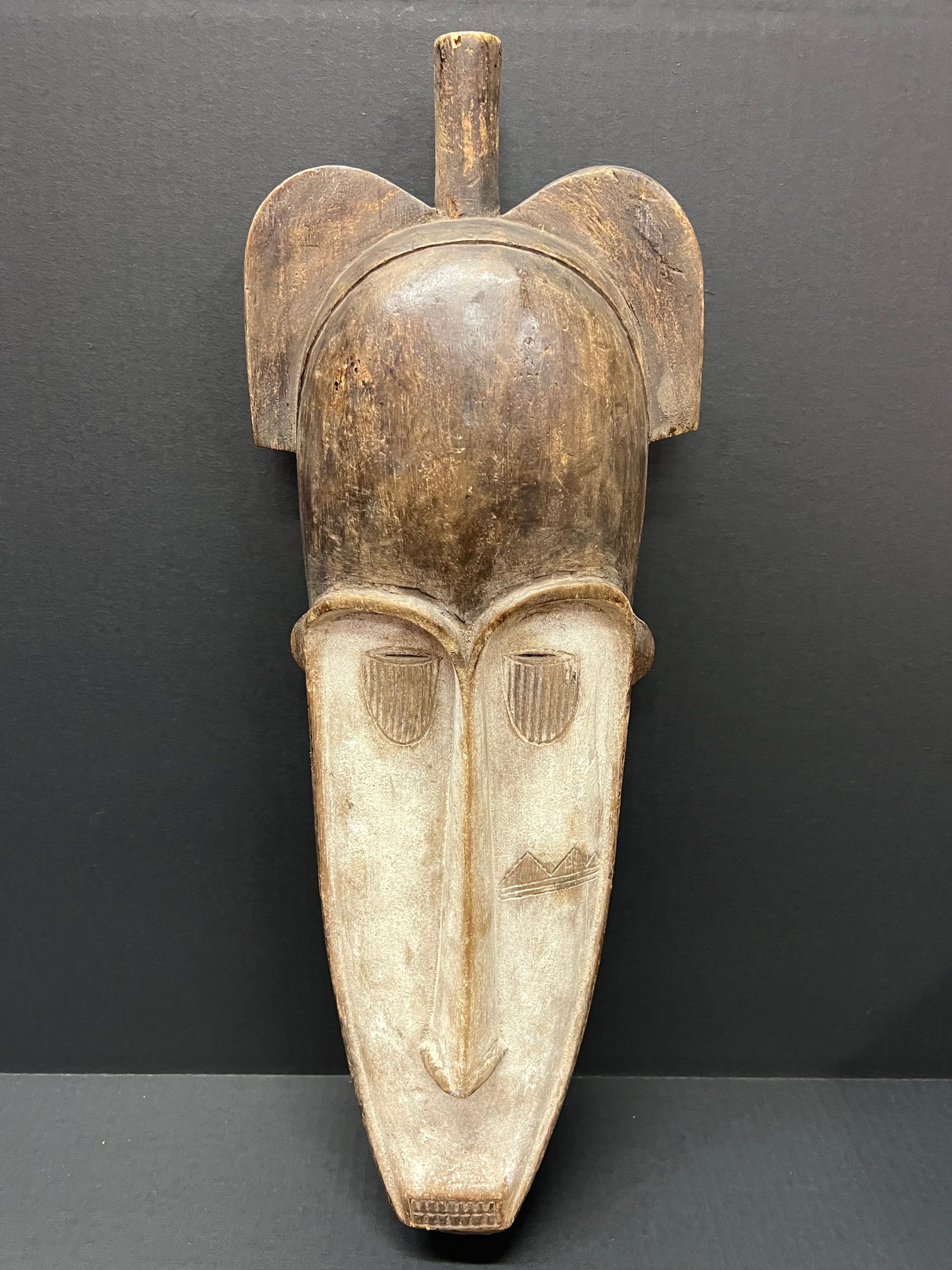Carved Wood Fang Mask: African Tribal Art Carved Wood Fang Mask. The dimension is 23 inches high x 8 inches wide. Please be aware that some of the items are vintage, secondhand, old ages, antiques and may have a defects or 