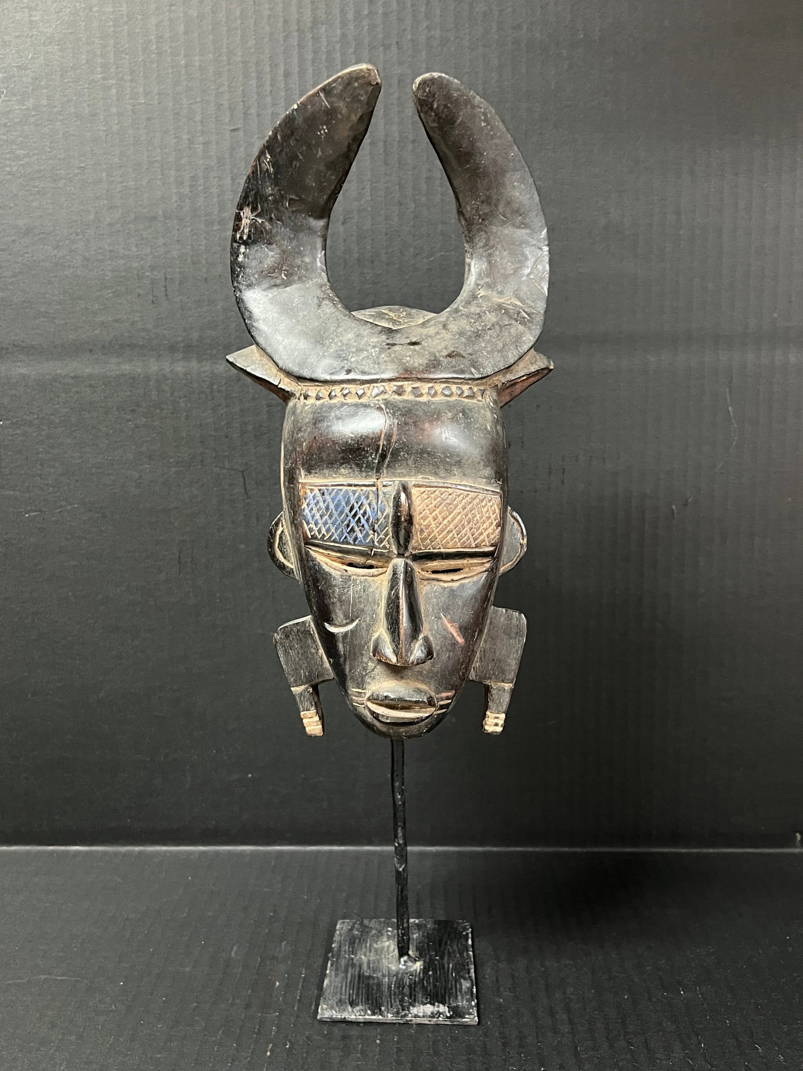 Carved Wood Kulango Mask with Stand: African Tribal Art Carved Wood Kulango Mask. The dimension is 16.5 inches high x 6.5 inches wide. Please be aware that some of the items are vintage, secondhand, old ages, antiques and may have a defe