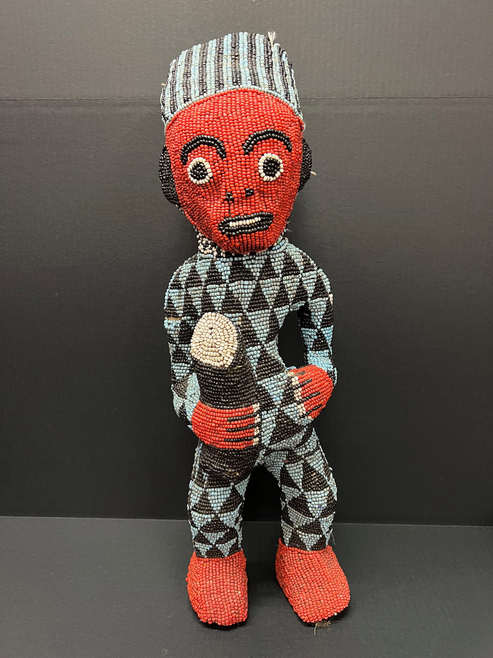 Carved Wood And Beaded Bamileke Statue: African Tribal Art Carved Wood and Beaded Bamileke Statue. The dimension is 26 inches high x 8 inches wide. Please be aware that some of the items are vintage, secondhand, old ages, antiques and may h
