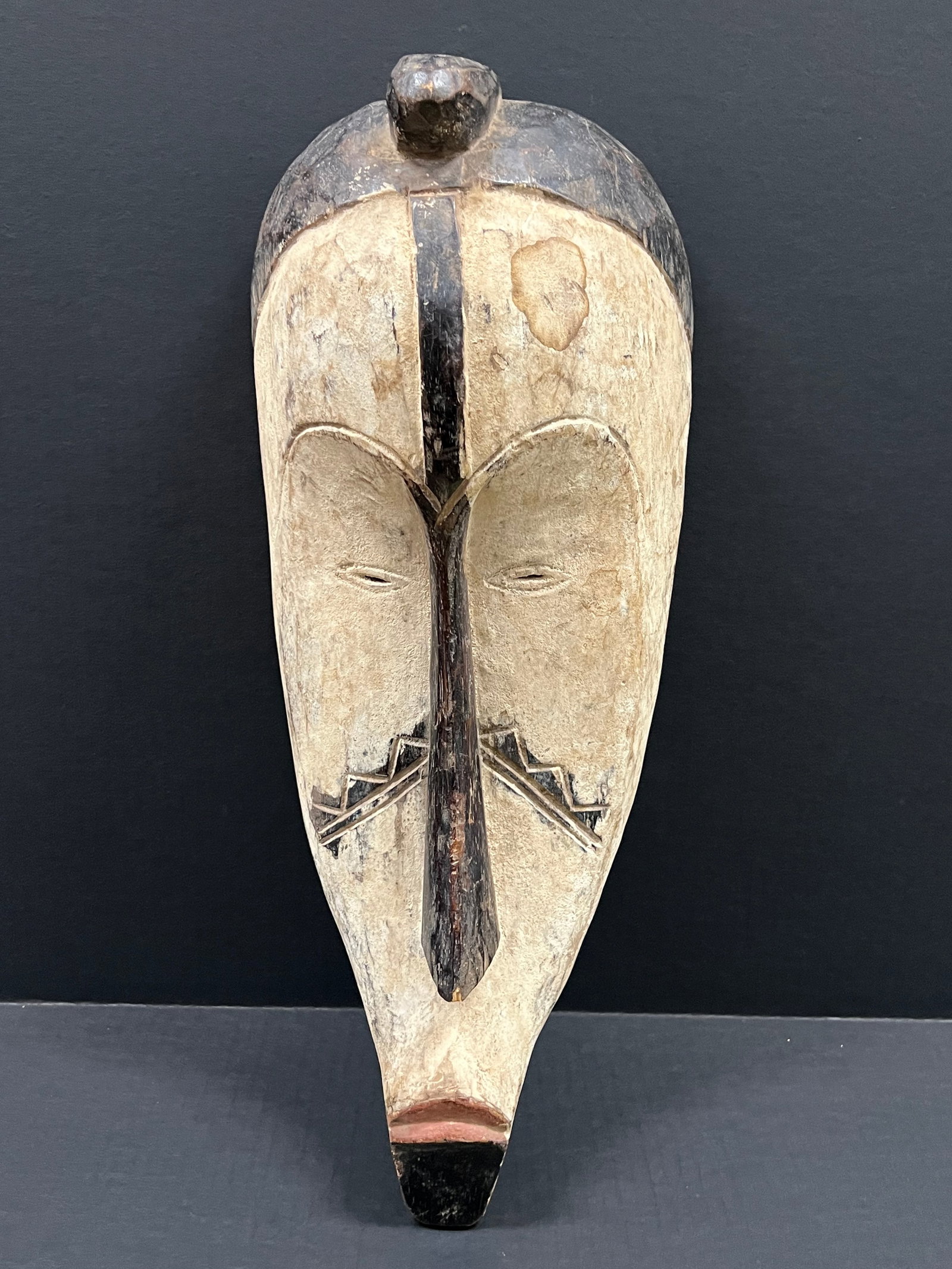Carved Wood Fang Mask: African Tribal Art Carved Wood Fang Mask. The dimension is 17.5 inches high x 8 inches wide. Please be aware that some of the items are vintage, secondhand, old ages, antiques and may have a defects o