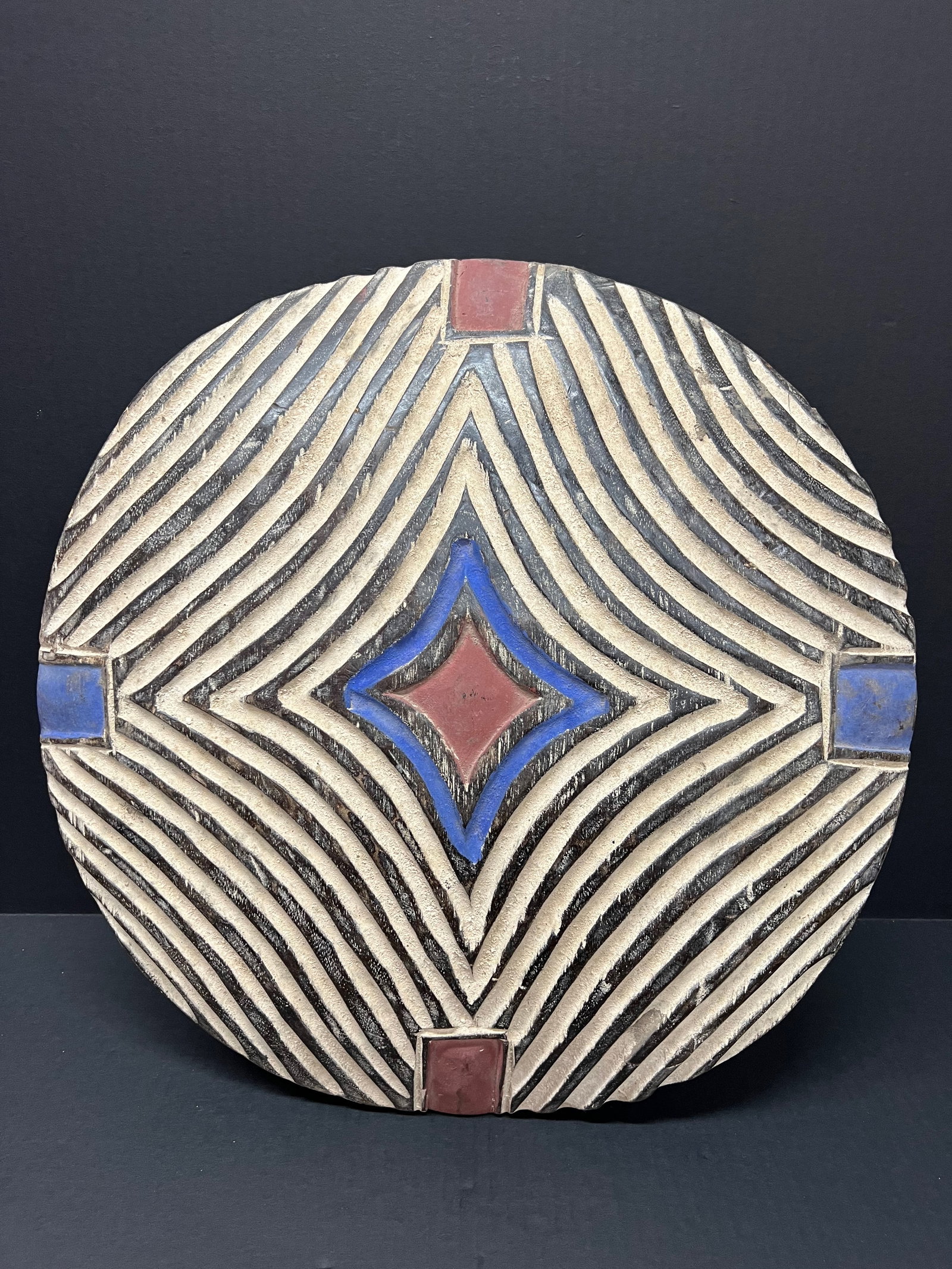 Carved Wood Zulu Shield: African Tribal Art Carved Wood Zulu Shield. The dimension is 20 inches high x 20 inches wide. Please be aware that some of the items are vintage, secondhand, old ages, antiques and may have a defects 