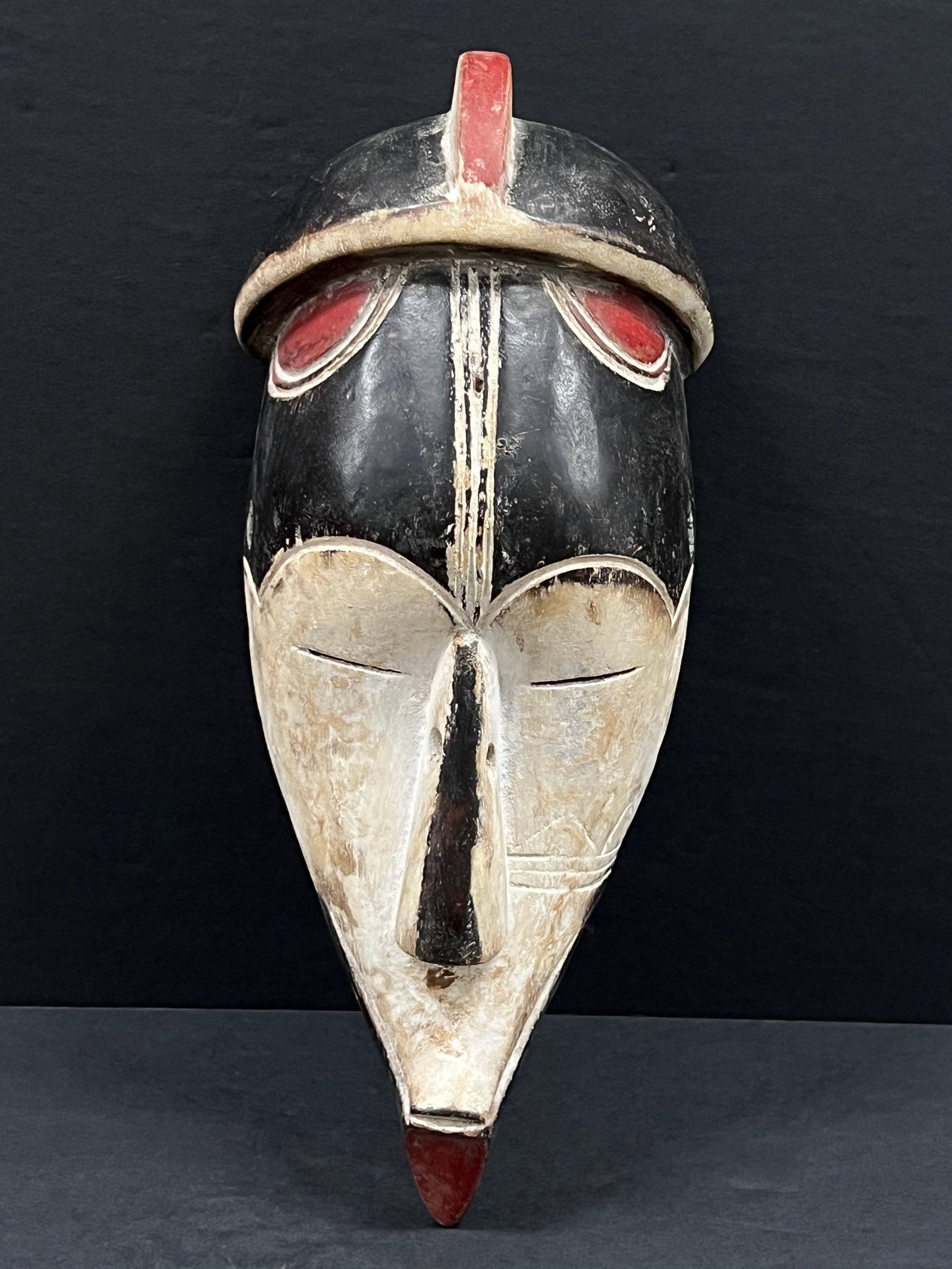 Carved Wood Fang Mask: African Tribal Art Carved Wood Fang Mask. The dimension is 12 inches high x 5 inches wide. Please be aware that some of the items are vintage, secondhand, old ages, antiques and may have a defects or 