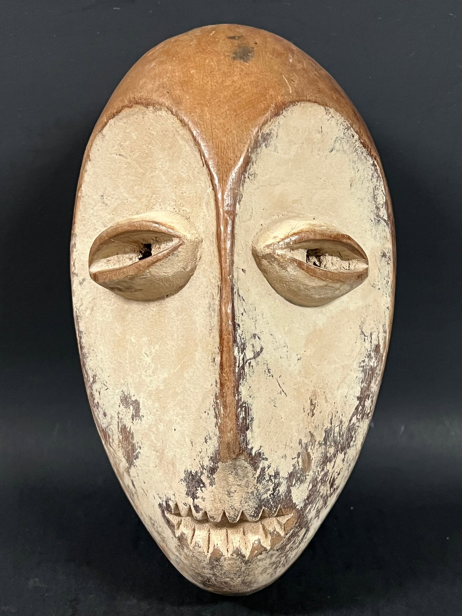 Carved Wood Lega Mask: African Tribal Art Carved Wood Lega Mask. The dimension is 10.5 inches high x 6.5 inches wide. Please be aware that some of the items are vintage, secondhand, old ages, antiques and may have a