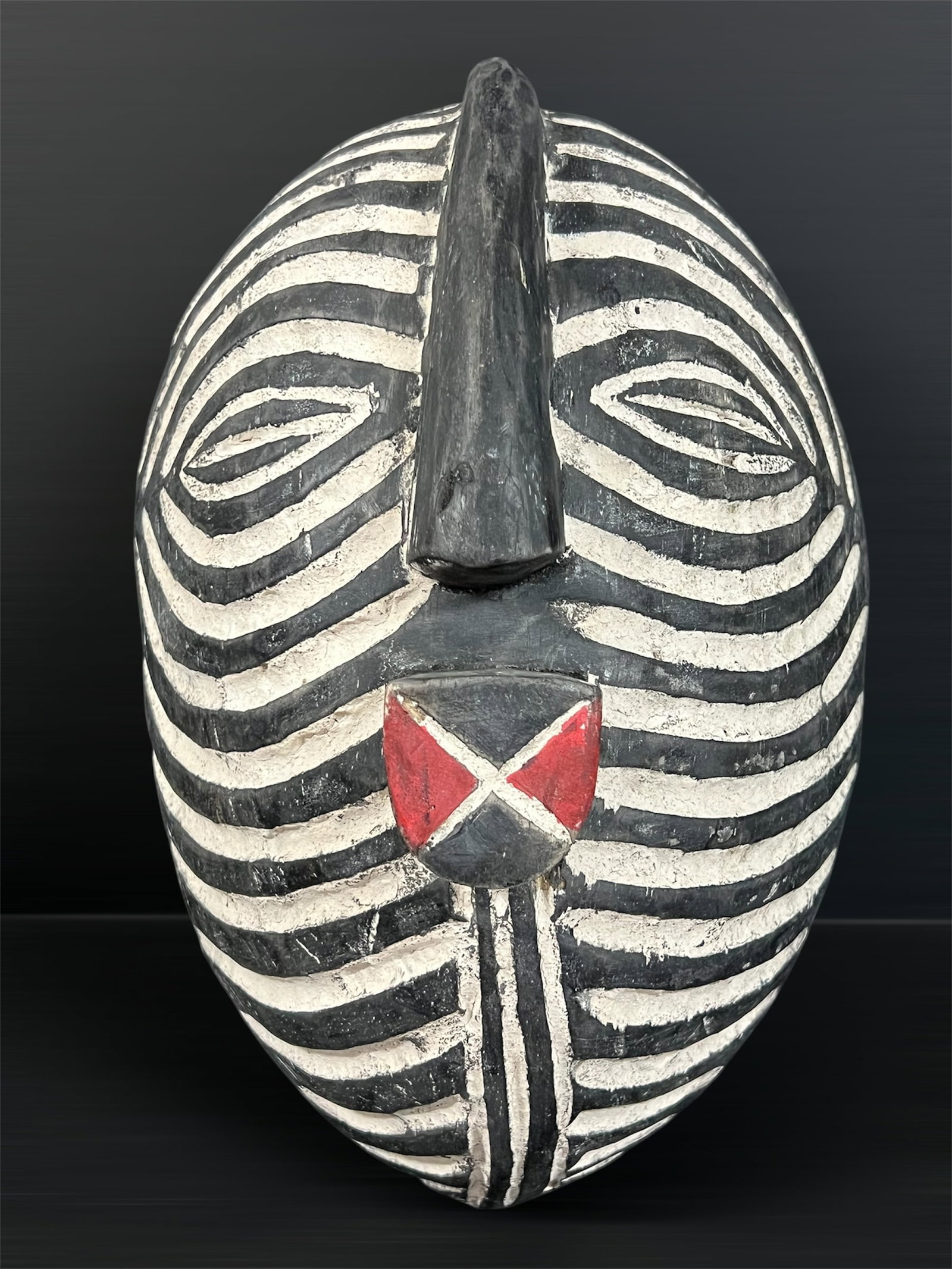 Carved Wood Songye Mask: African Tribal Art Carved Wood Songye Mask. The dimension is 13 inches high x 9 inches wide. Please be aware that some of the items are vintage, secondhand, old ages, antiques and may have a defects o