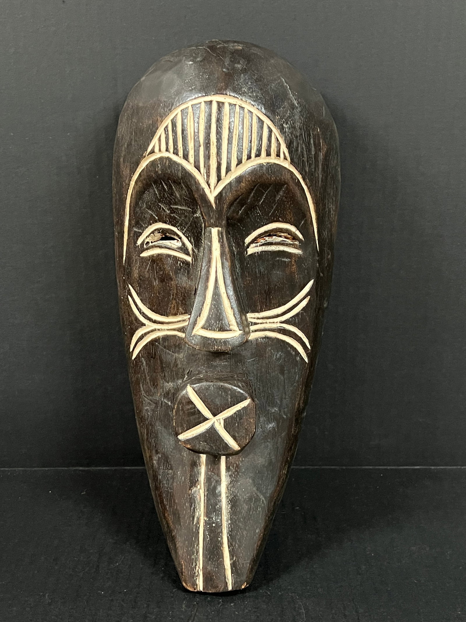 Carved Wood Songye Mask: African Tribal Art Carved Wood Songye Mask. The dimension is 15 inches high x 7 inches wide. Please be aware that some of the items are vintage, secondhand, old ages, antiques and may have a defects o