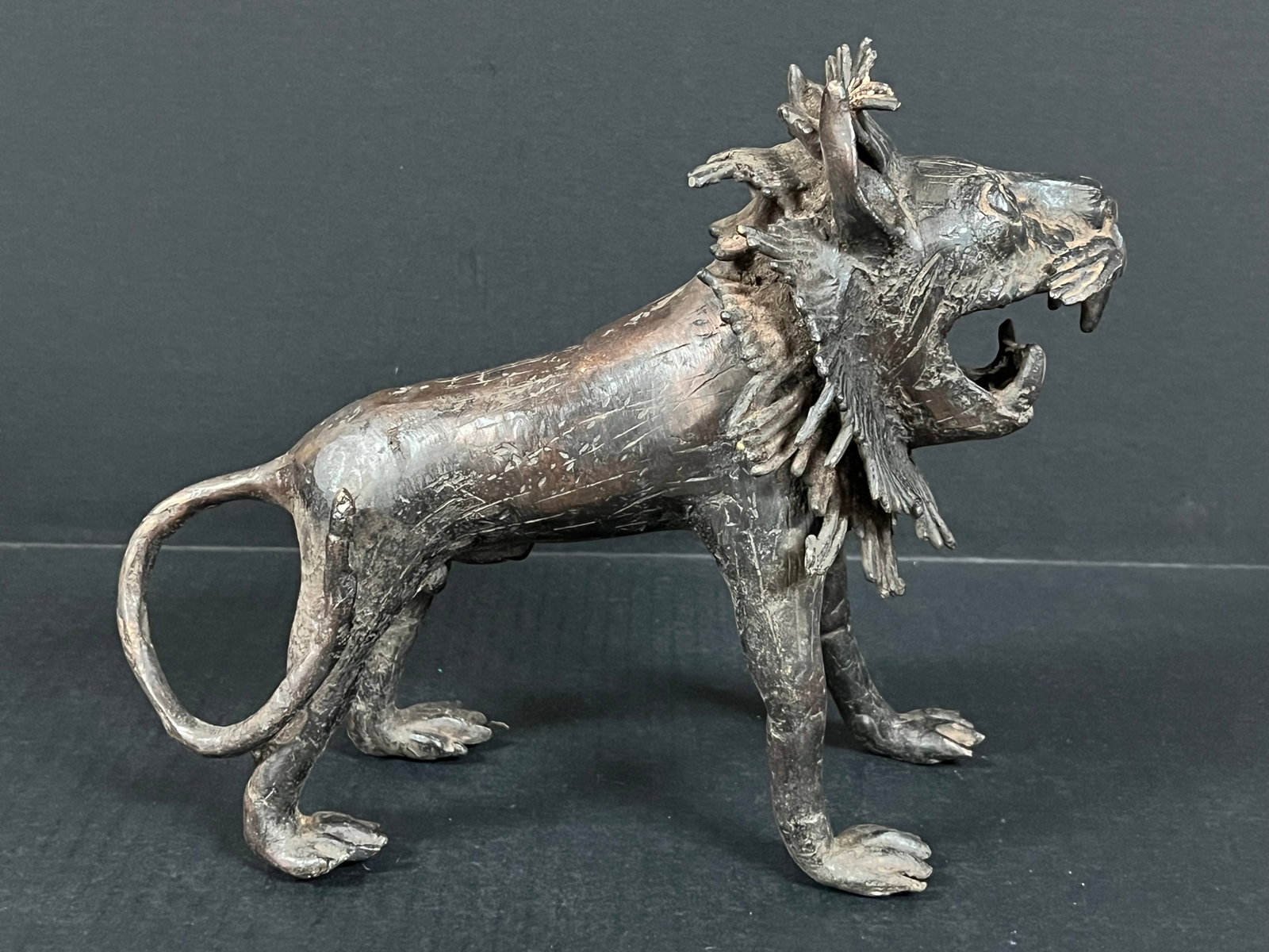 Benin Bronze Lion Sculpture: African Tribal Art Benin Bronze Lion Sculpture. The dimension is 9 inches high x 10.5 inches wide. Please be aware that some of the items are vintage, secondhand, old ages, antiques and may have a def