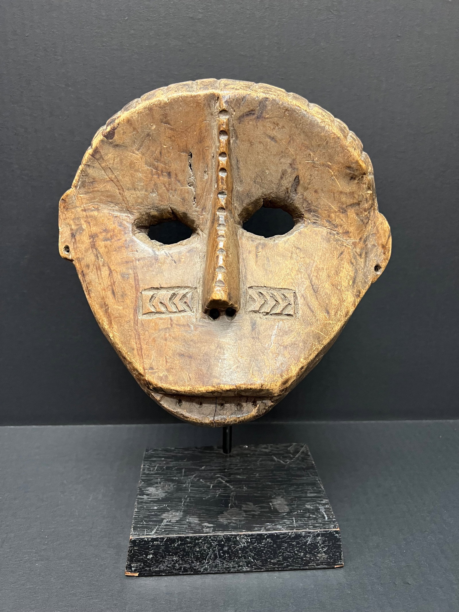 Carved Wood Bacongo Mask with Display Stand: African Tribal Art Bacongo Mask With Display Stand. The dimension is 13 inches high x 9.5 inches wide. Please be aware that some of the items are vintage, secondhand, old ages, antiques and may have a