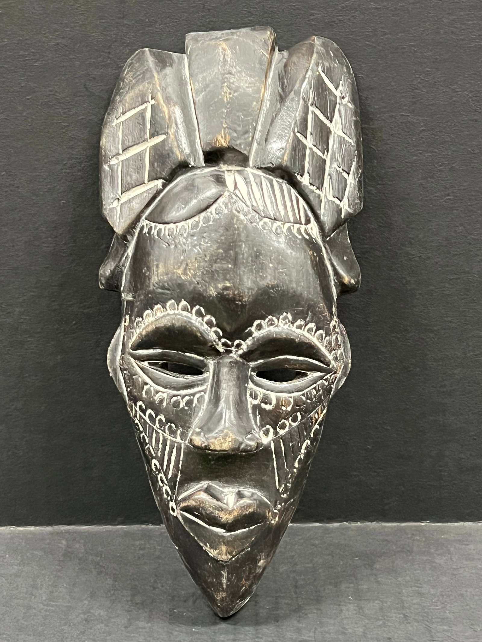 Carved Wood Tikar Mask: African Tribal Art Carved Wood Tikar Mask. The dimension is 9 inches high x 4.25 inches wide. Please be aware that some of the items are vintage, secondhand, old ages, antiques and may have a defects 