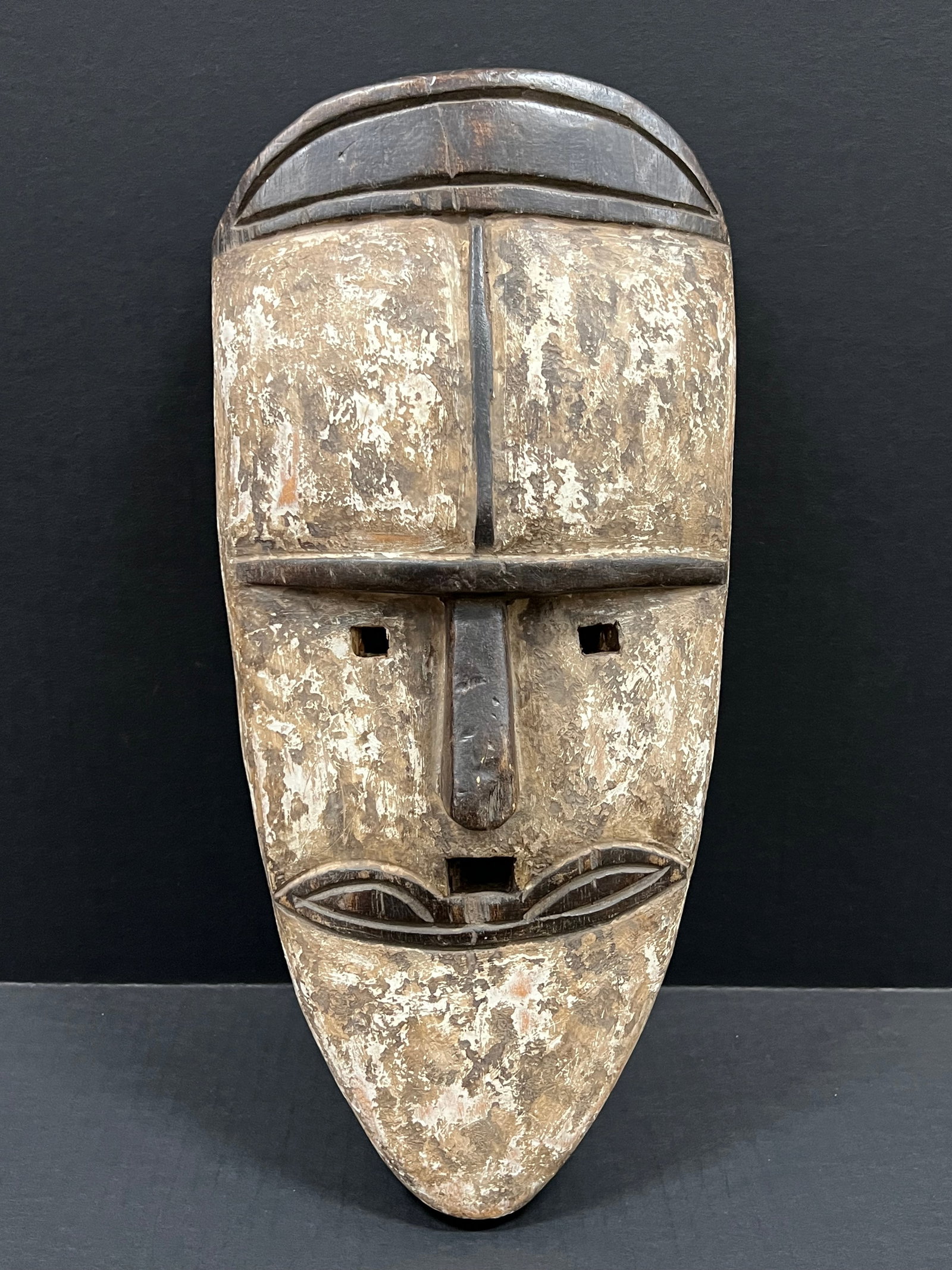 Carved Wood Fang Mask: African Tribal Art Carved Wood Fang Mask. The dimension is 21.5 inches high x 10 inches wide. Please be aware that some of the items are vintage, secondhand, old ages, antiques and may have a defects 